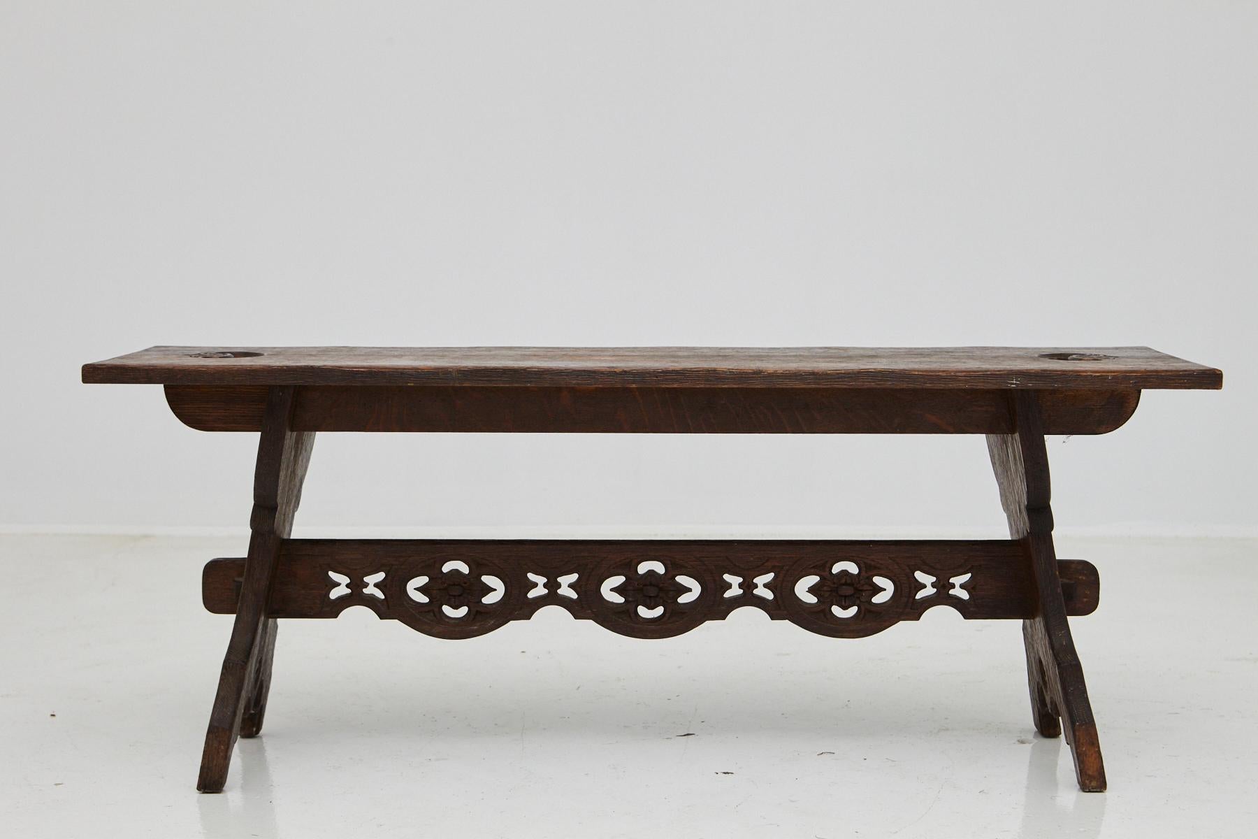 19th century Austrian hand carved rustic trestle oak bench, with carved details in the trestle and two carved handles at the top of the bench.
Very good condition, normal scratches from usage, great patina.