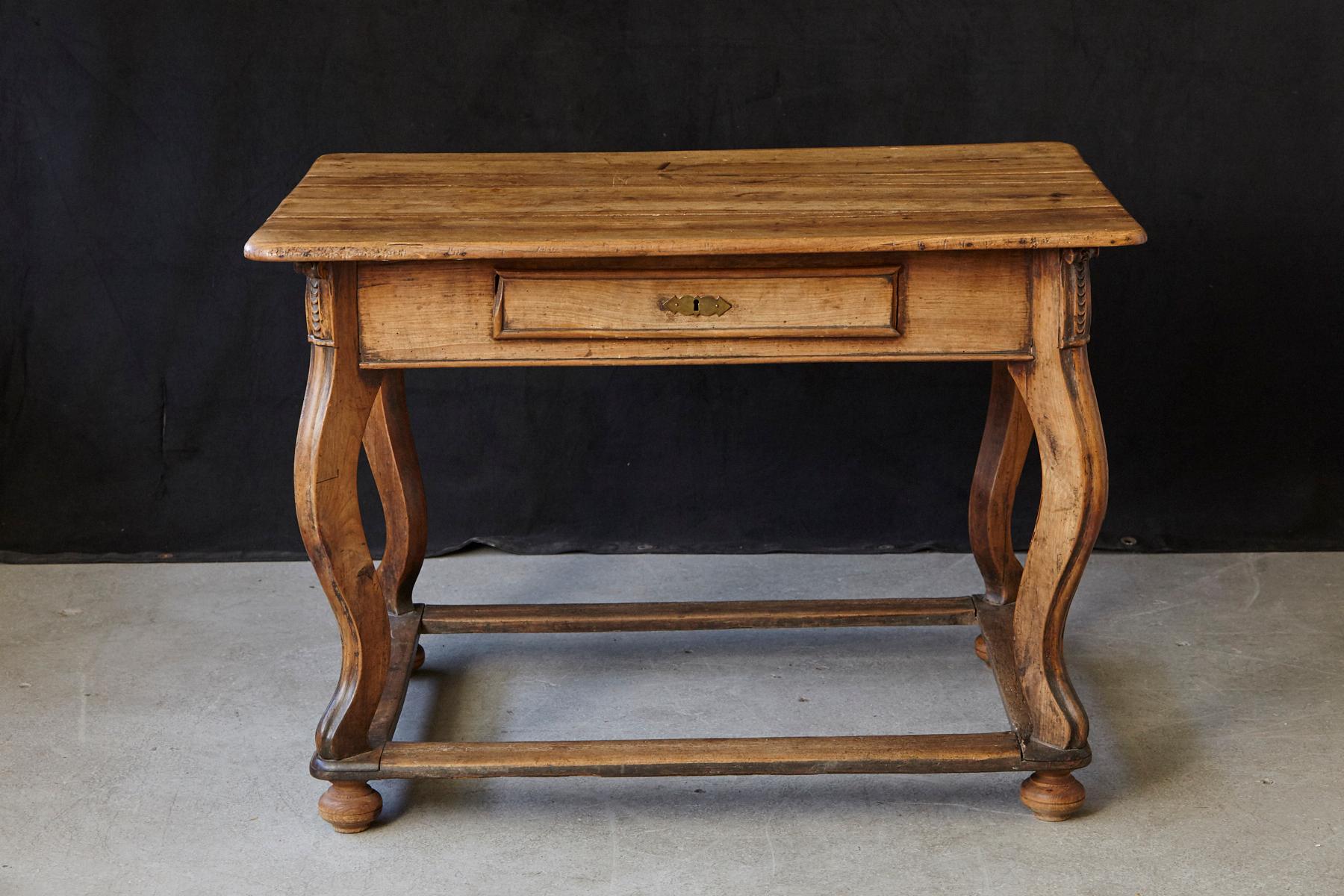 Beautiful, puristic Austrian farm house table in fruitwood with a beautiful patina good for multiple purposes as a kitchen table of library table for example.
Slightly scrolled legs mounted on a box stretcher, simple carvings on the corners, a