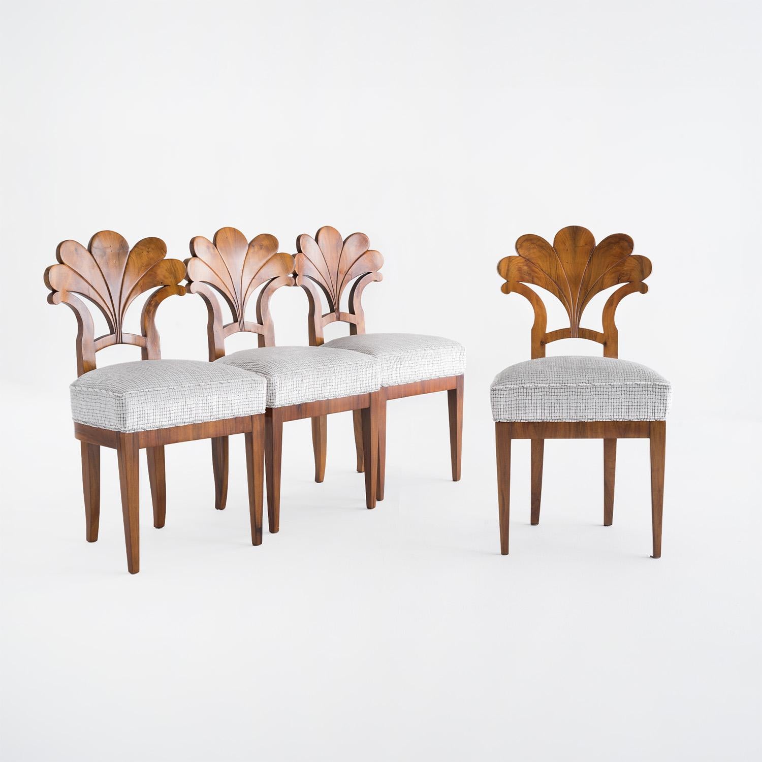 Un ensemble antique de quatre chaises de salle à manger autrichiennes du début du 19e siècle, en noyer partiellement plaqué et poli à la gomme-laque, en bon état. Les chaises d'appoint détaillées ont un dossier légèrement incurvé à décor floral et