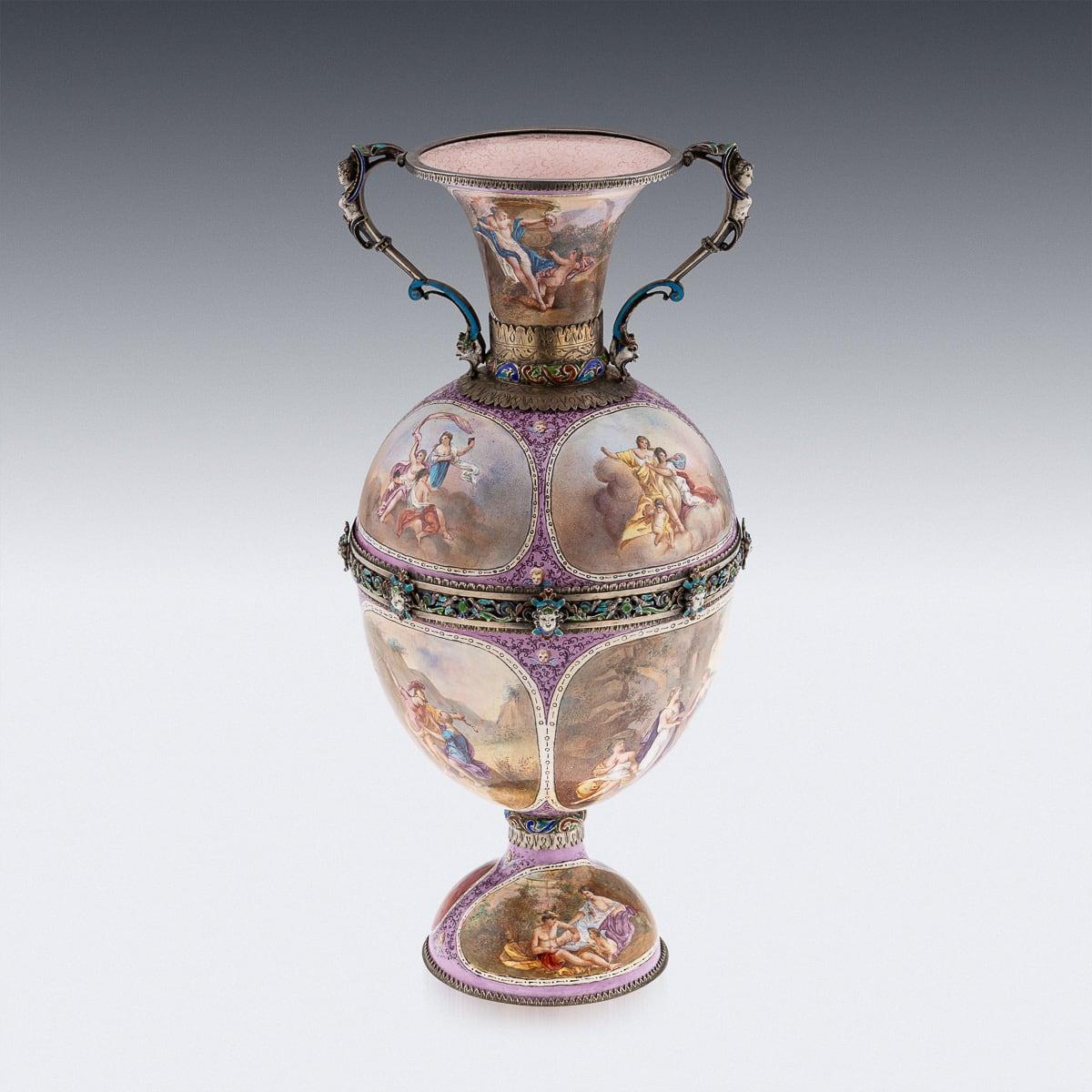 Antique late-19th Century An exceptional Austrian solid silver gilt and enamel twin-handled vase. It stands on a domed base adorned with strapwork bands featuring pierced foliage and masks. The caryatid handles end in female busts, while the body