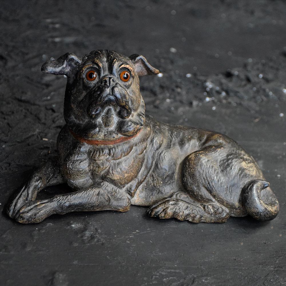 19th century Austrian terracotta pug 

Hand crafted in the late 19th century, a fine figure of a recumbent terracotta pug with glass eyes. Stamped at the base with the number 195, this delightful figure is both highly collectable and rare due to