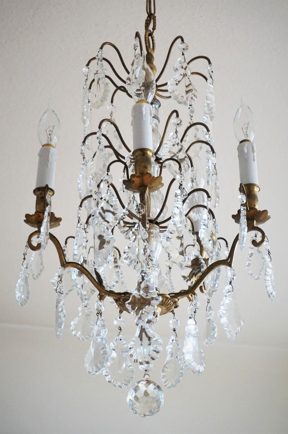 A lovely antique Baccarat crystal electrified chandelier, gilt brass beautifully decorated with several tiers of large pendaloques in different shapes and sizes, finishing at the bottom with a large clear cut crystal ball, including chain and
