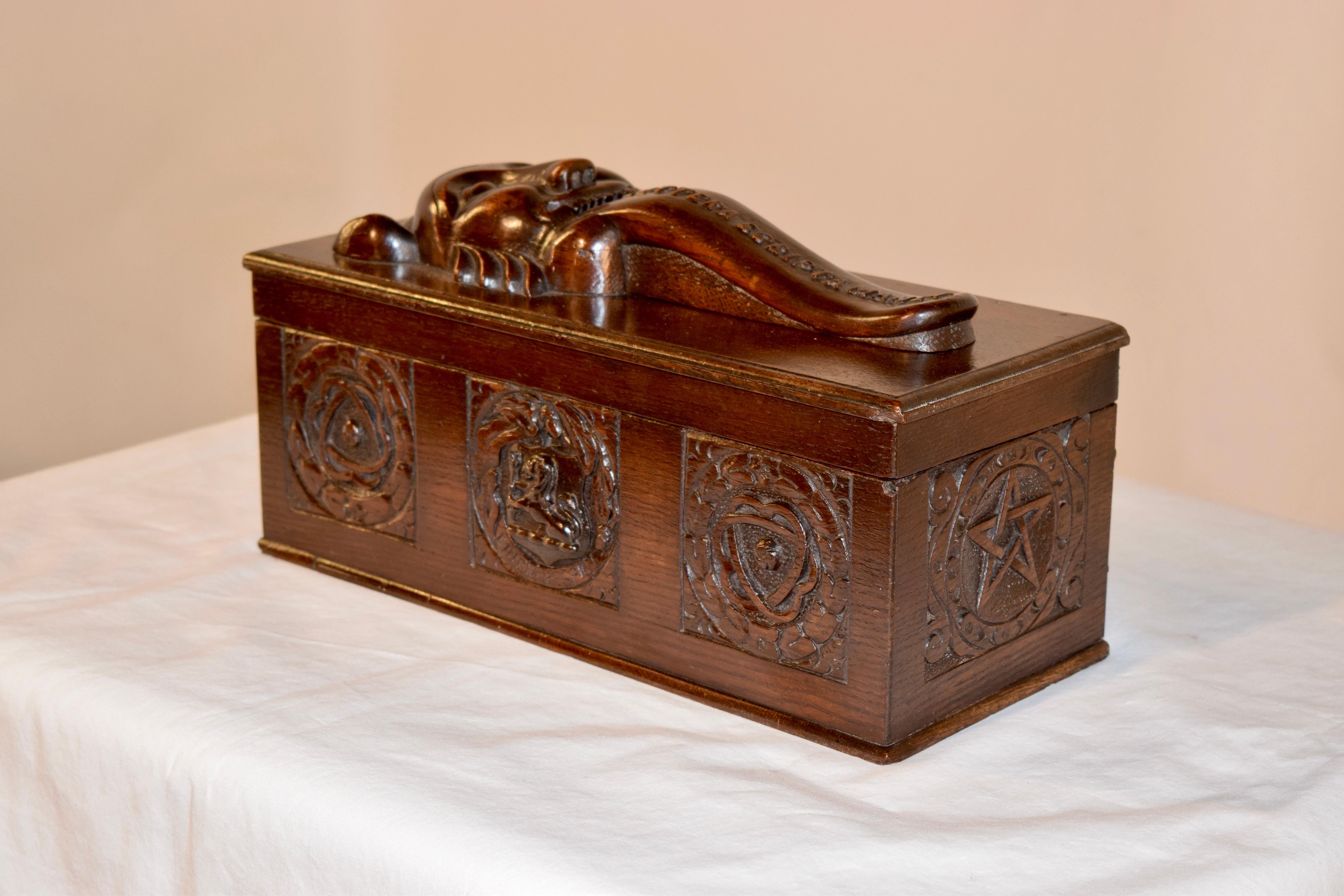 19th century ballot box from England with a carved head atop the box which has a tongue that has hand carved 