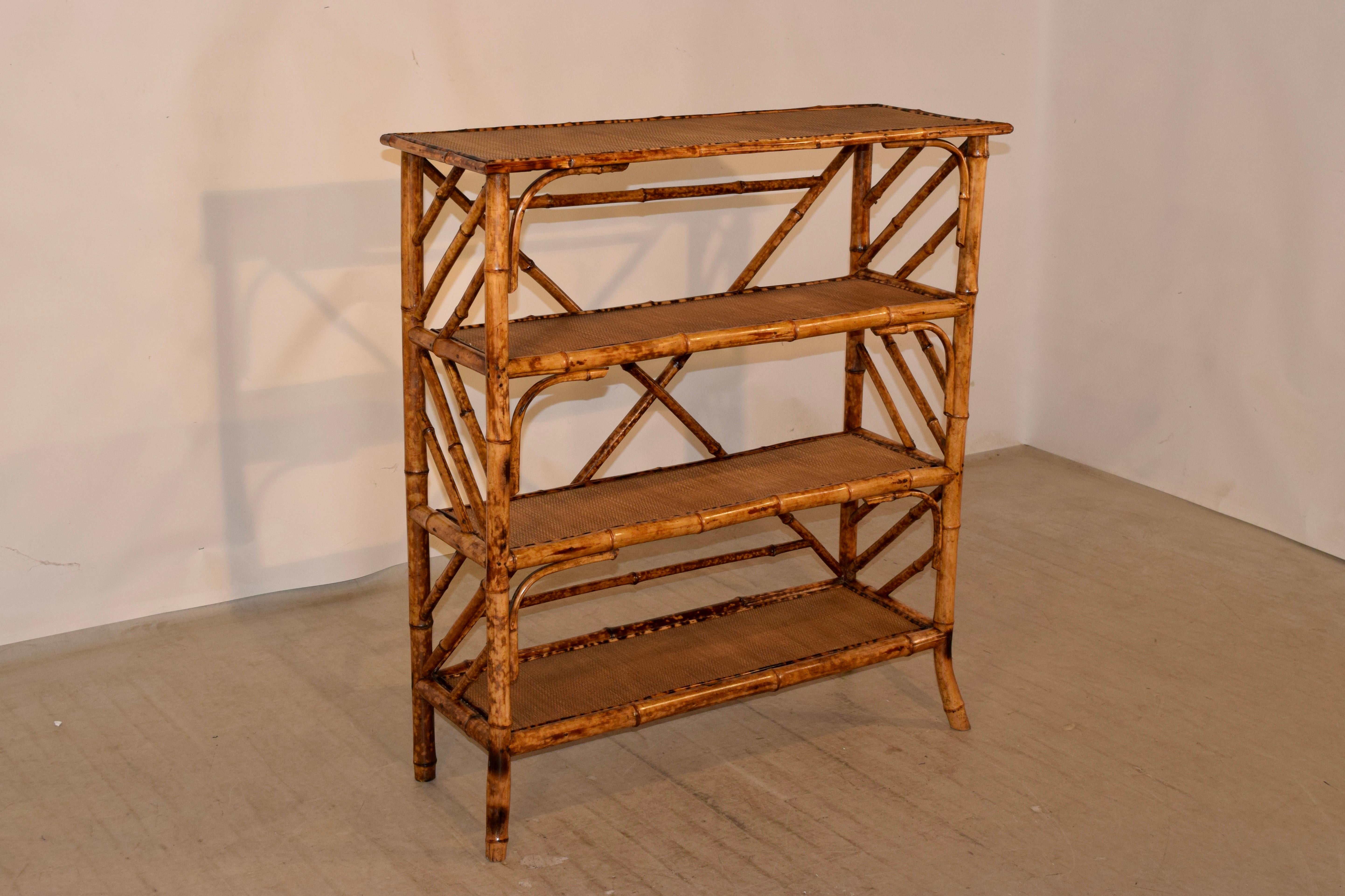 19th century bamboo bookcase from France with rush covered shelves and unusual decorative accents throughout. The front legs are splayed and the back legs straight for easy placement against a wall.