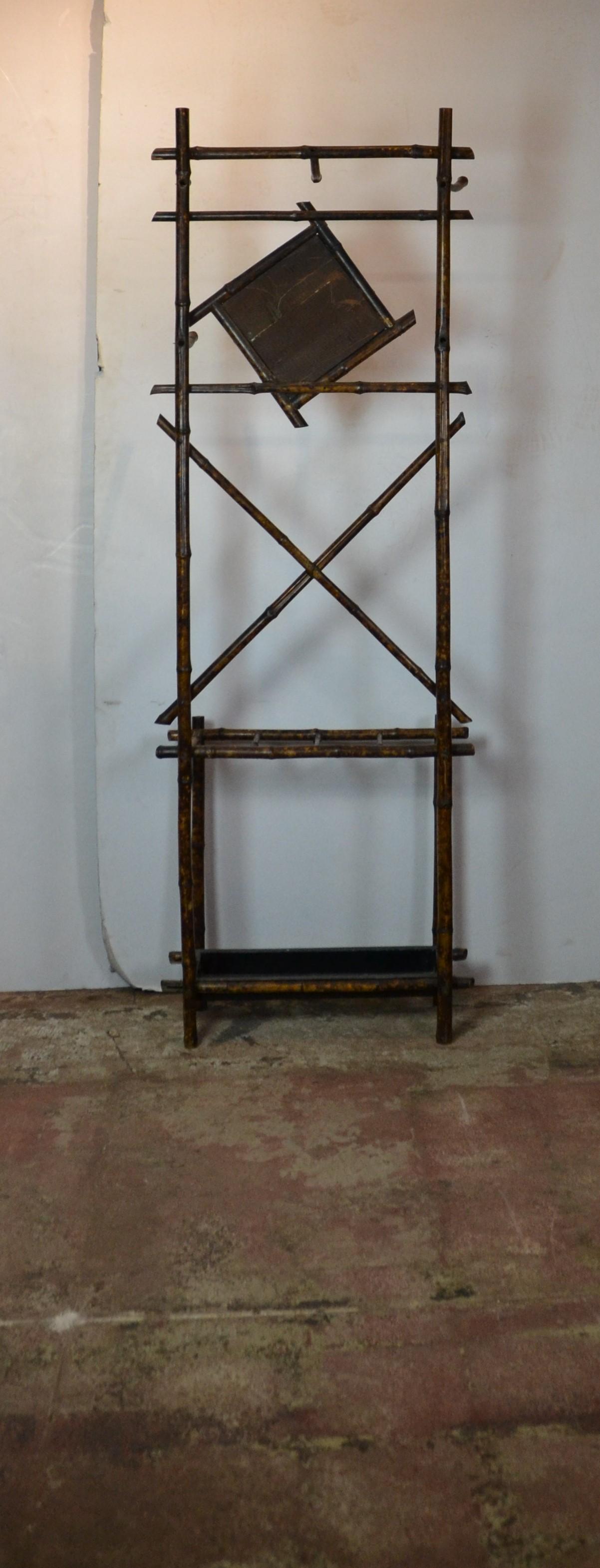 19th century English bamboo coat rack. The top part has a triangle shape mirror the bottom has a tole tray to store umbrella.
