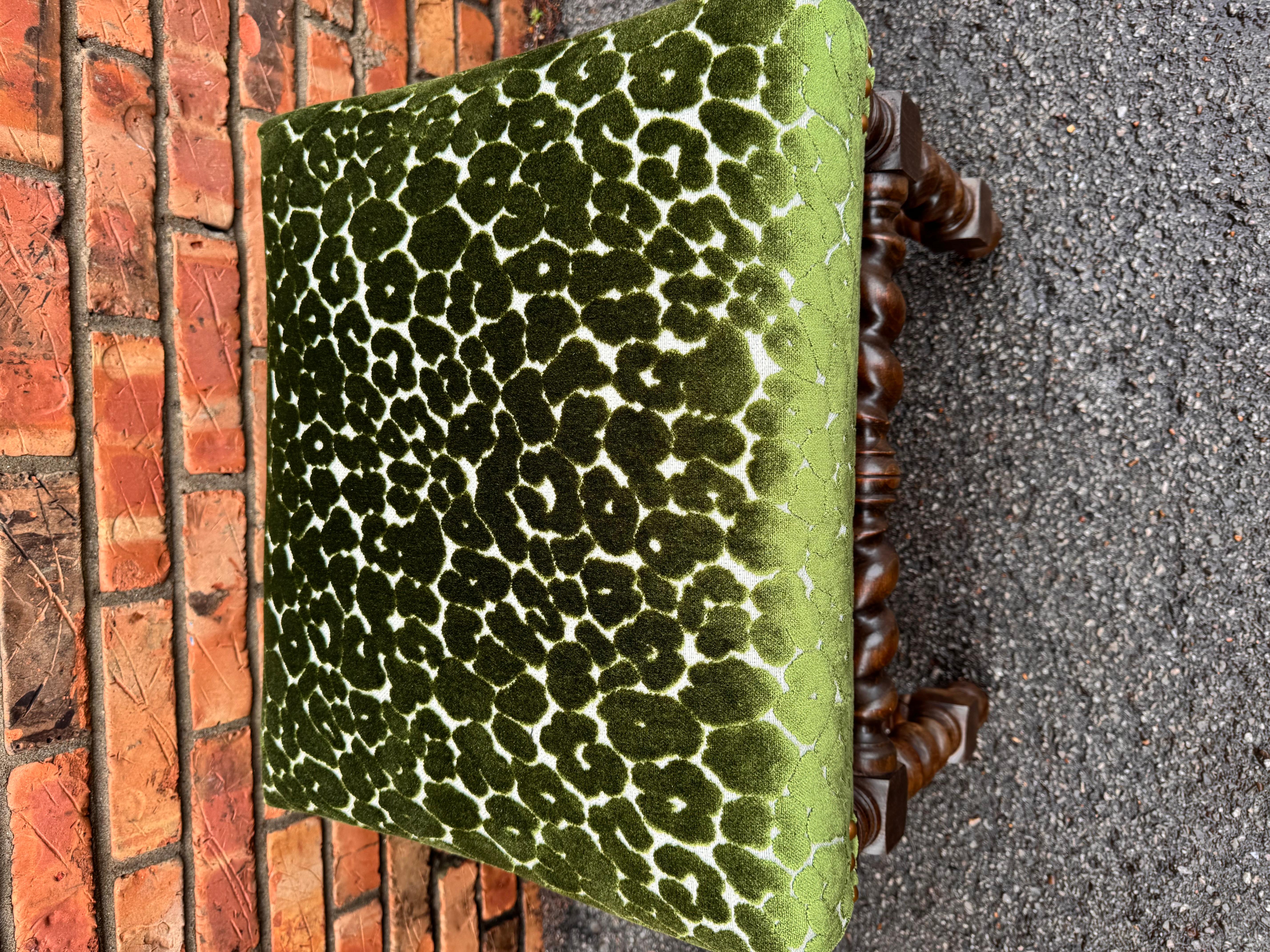 This is a beautiful newly upholstered antique bench. The fabric is a stunning emerald green, crushed velvet material. The base is solid, hand carved wood, rich brown color that pairs wonderfully with the green fabric and brass nail heads. It would