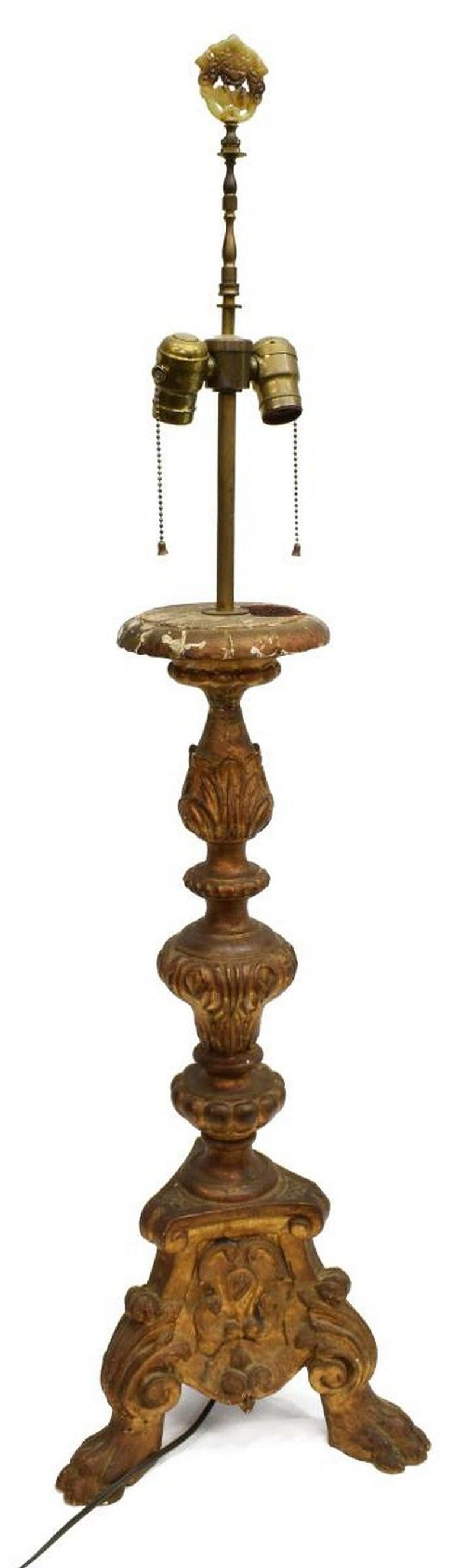 A stunning Continental Baroque well carved wooden altar candle holder pricket from the 19th century, now fashioned as a tall two-light table lamp, with foliate bands, the standard with heraldic imagery, rising on paw feet. Having a jade final with