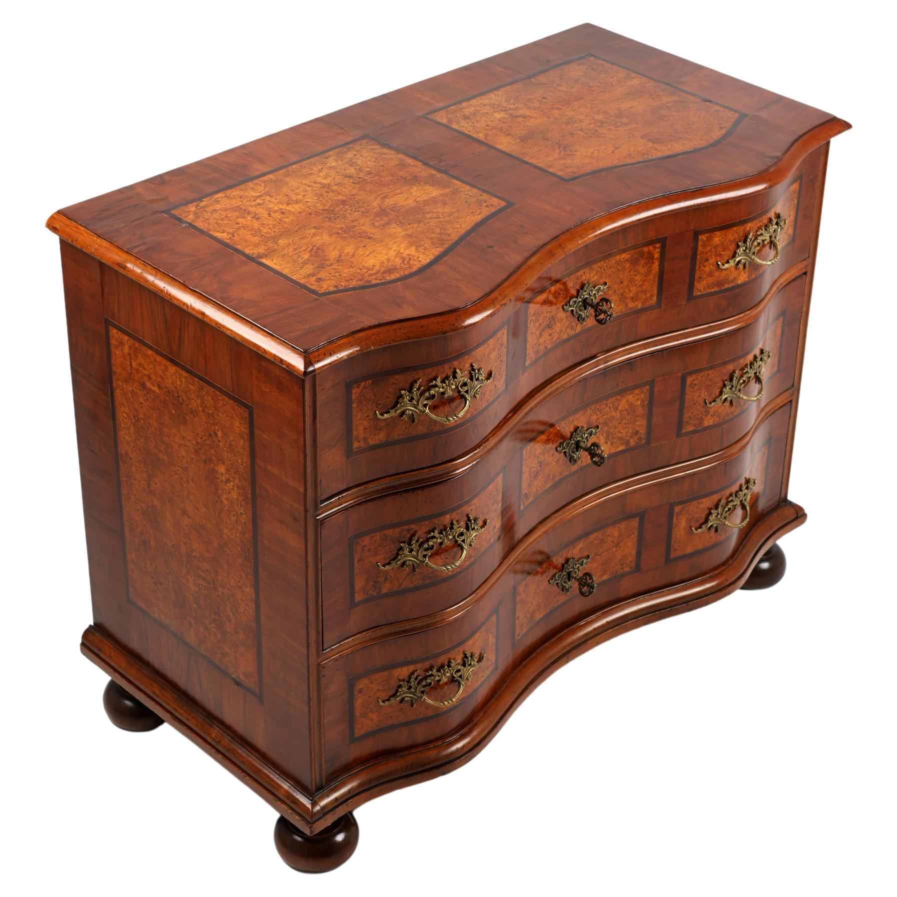 Late XIX Century Chest of Drawers in Baroque Style,
Germany, 1890
Walnut with burl wood,

A chest of drawers standing on spherical legs and in a beautiful form with a wavy front. Pine body, veneered with walnut. The furniture is decorated with