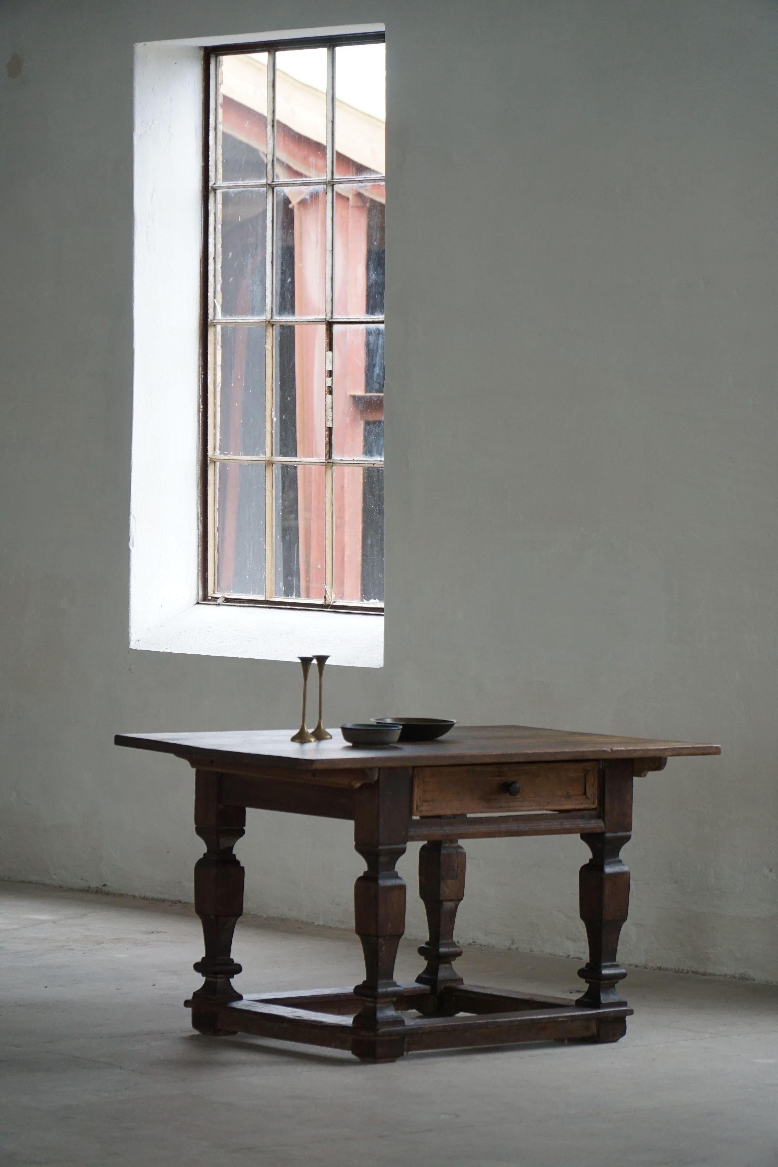 Table robuste et caractéristique du XIXe siècle en chêne massif, fabriquée au Danemark dans les années 1800. Cette pièce illustre la force architecturale de la période baroque, avec des pieds tournés audacieux, une base étirée et un seul