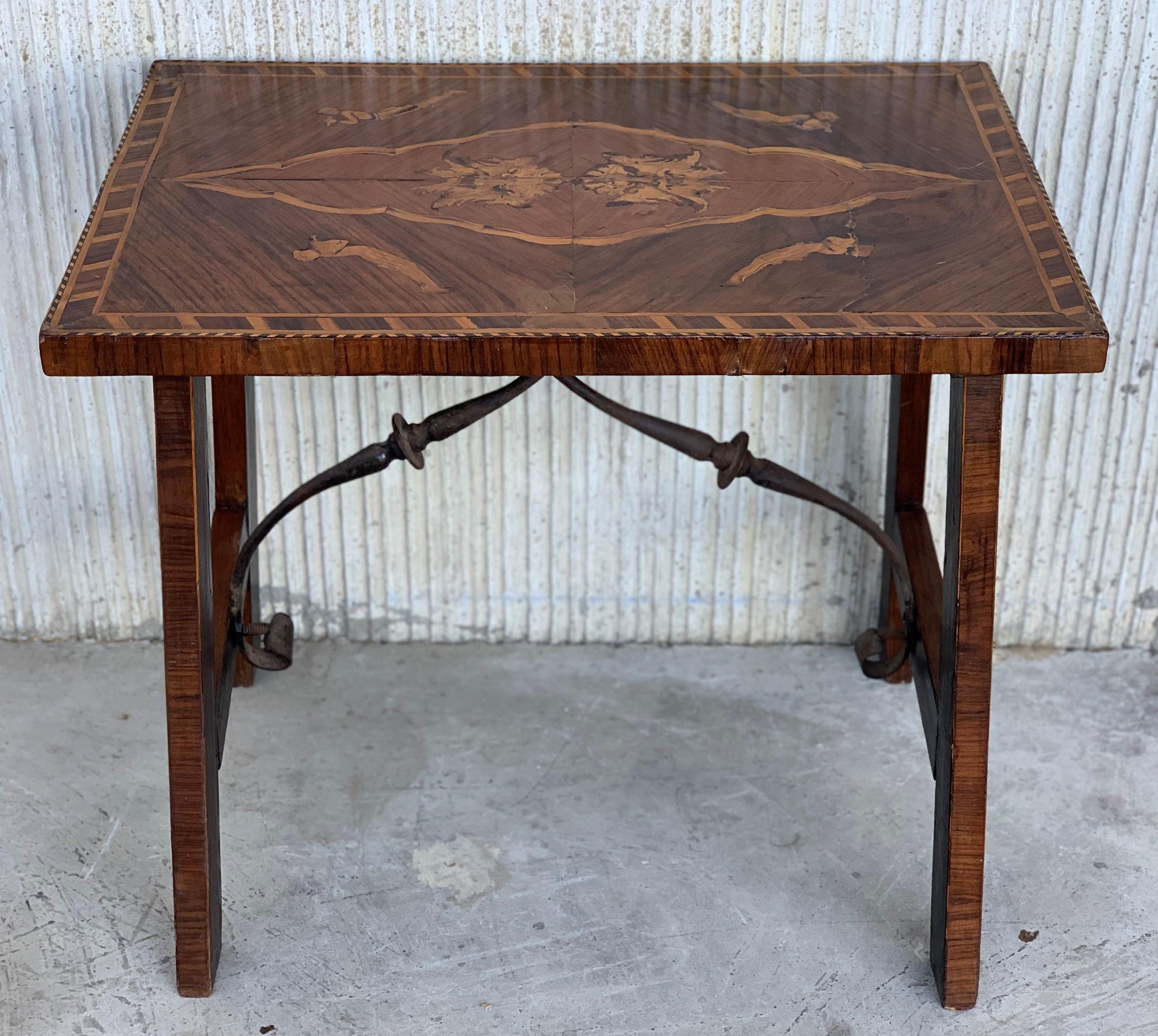 19th century Spanish trestle table in mahogany. with Marquetry top featuring two head lions in the center top and four cherubs in the corner tops and marquetry in the four legs.
This piece has a great scale, lovely legs and beautiful marquetry top.