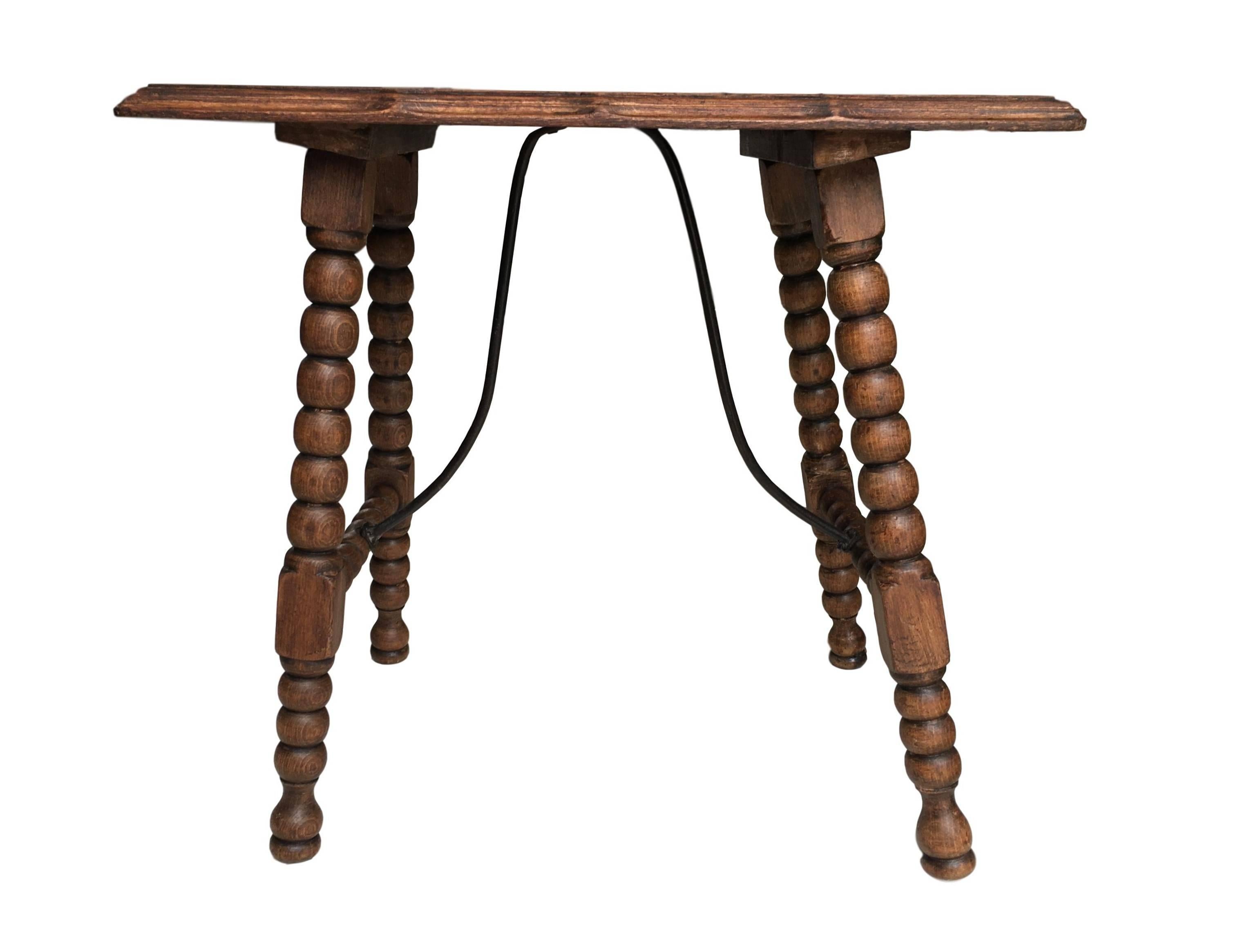 19th century Spanish trestle table in walnut and iron. This piece has a great scale, lovely turned legs and iron stretcher. The top is made from a single piece of wood. This table could be used as an end table, nightstand, side table, or small desk.