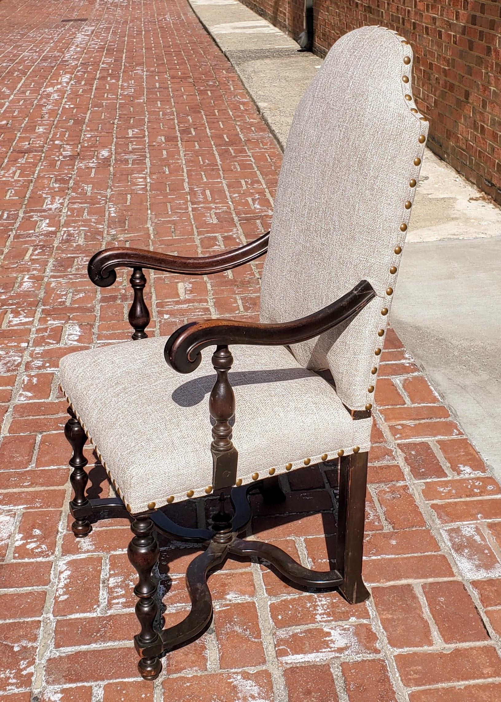 Lovely 19th century Baroque style french armchair. Made of richly patinated walnut with decoratively shaped backs. Two scrolled arms and turned legs with shaped “X” stretchers. Newly upholstered in textured taupe chenille with nailhead decoration.