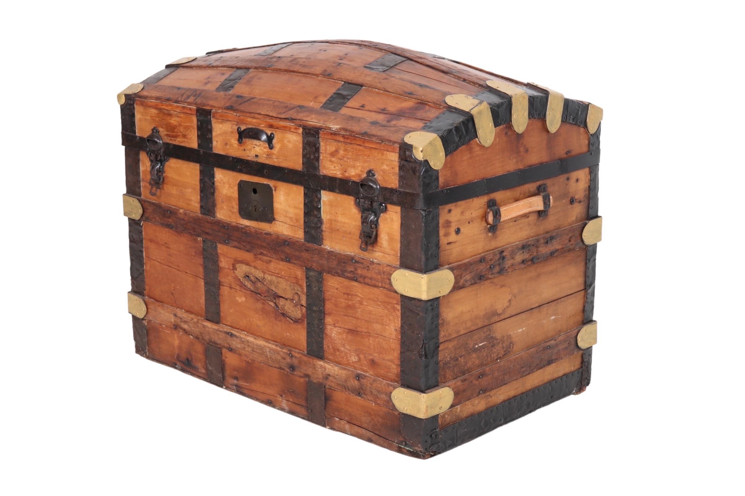 An antique barrel-stave steamer trunk dating from the mid 19th century. Made of oak, it has a domed lid with gold painted brass corners, black leather strapping and original iron hinges. Each end has a leather carrying handle and the interior is