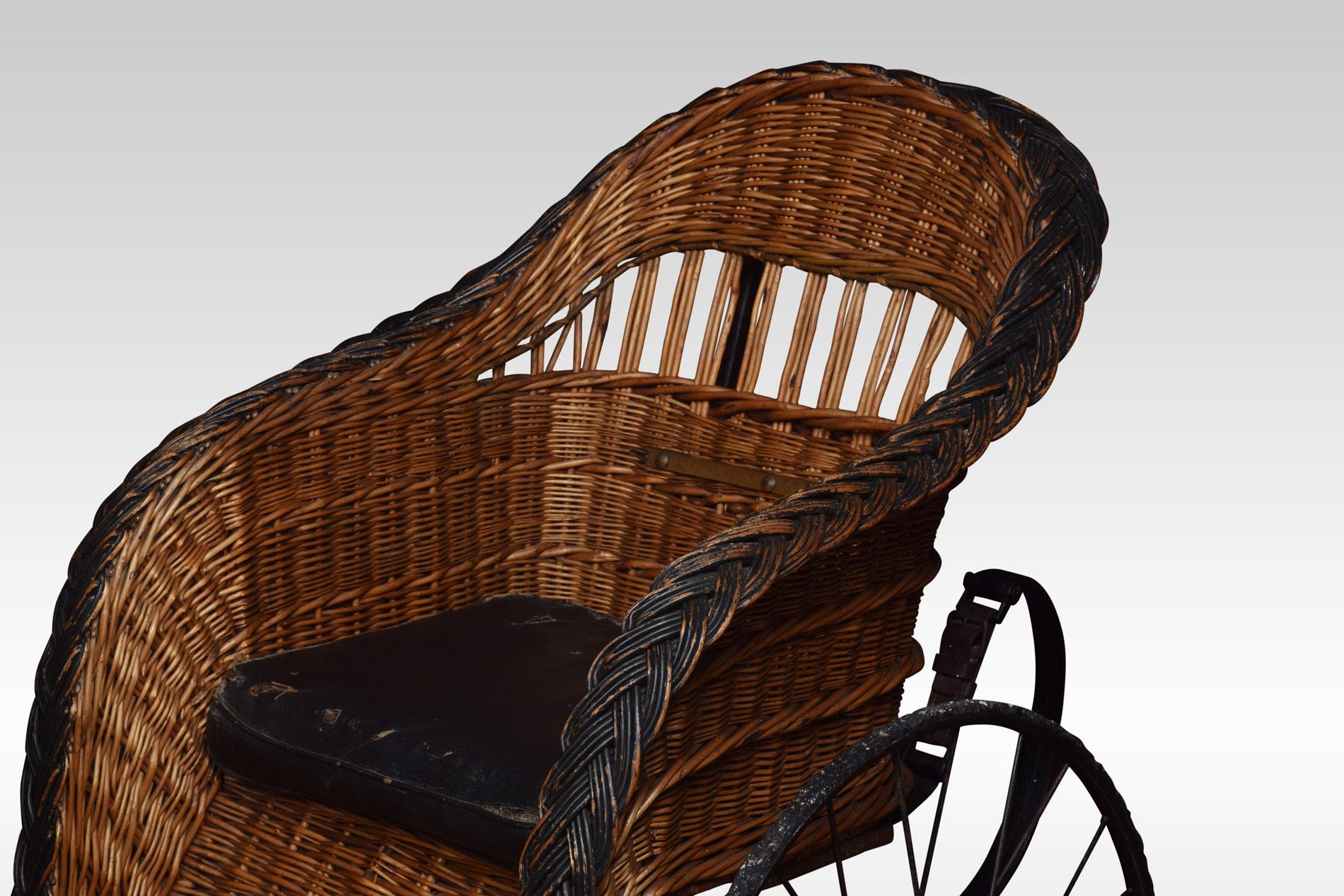 late-Victorian bath chair by John Ward London, with a wicker seat and spring carriage. All raised up on three wheels.

The bath chair is a forerunner to the modern wheelchair. It was invented by James Heath and gained popularity and its name when