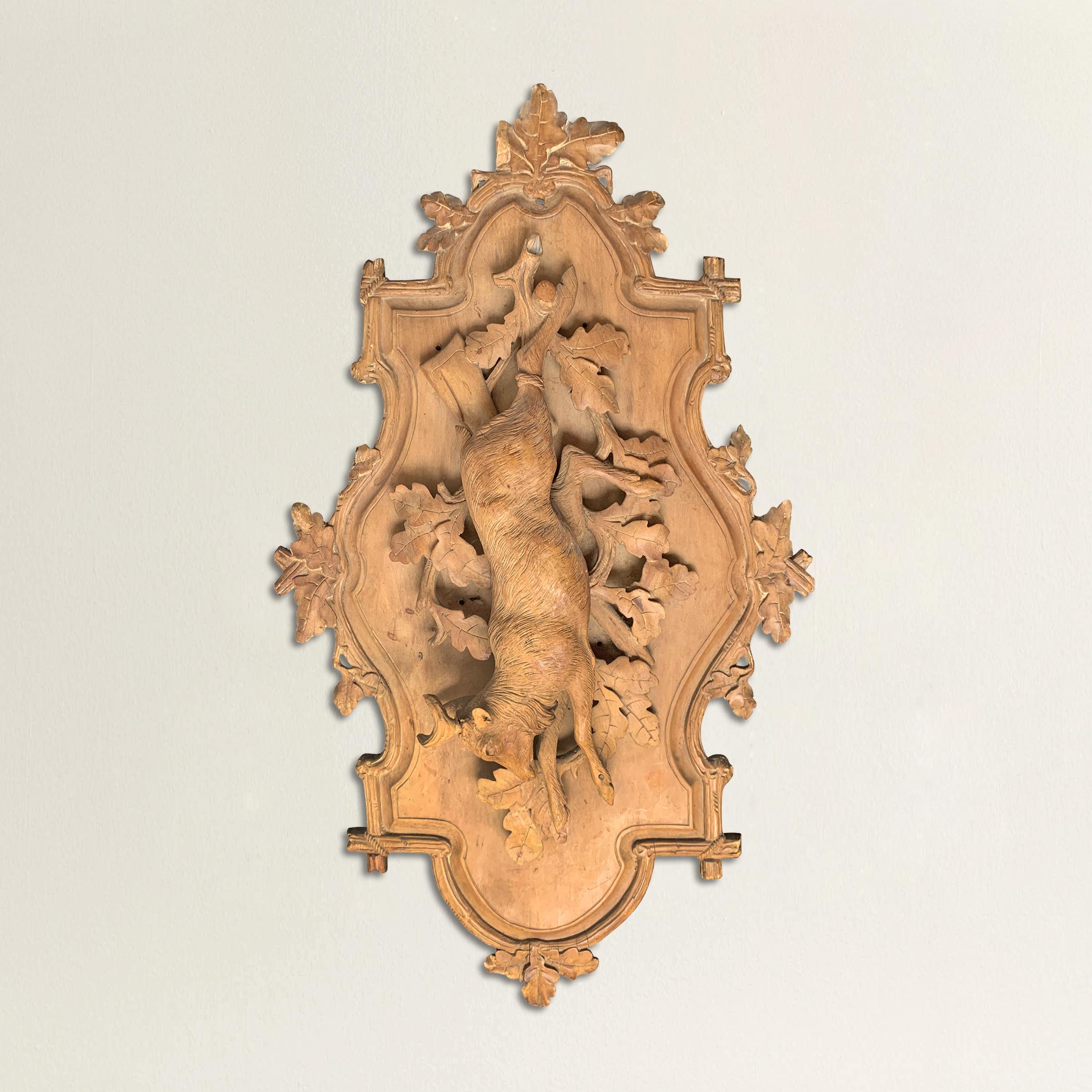 Une fantastique plaque de chasse en bois fruitier bavarois de la fin du 19ème siècle, sculptée à la main, représentant un chevreuil suspendu à une cheville en bois au-dessus d'une branche de chêne avec des feuilles et montée sur une planche avec un