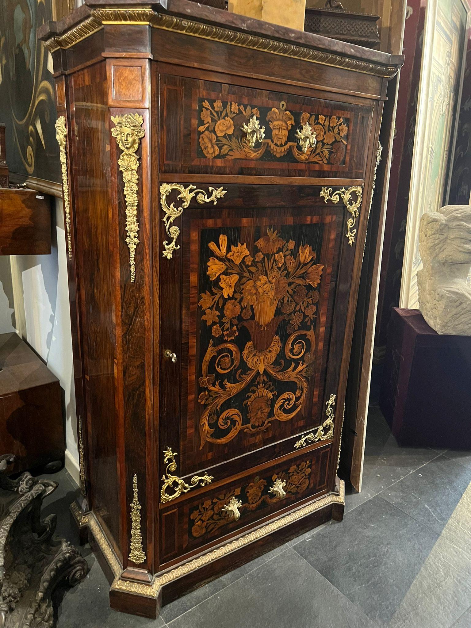 Elegant inlaid cabinet, this cabinet features a very high level inlay. In the central part there is a triumph of polychrome flowers framed by a sharpening, at the corners of which are mounted four bronze friezes which also appear in the rounded