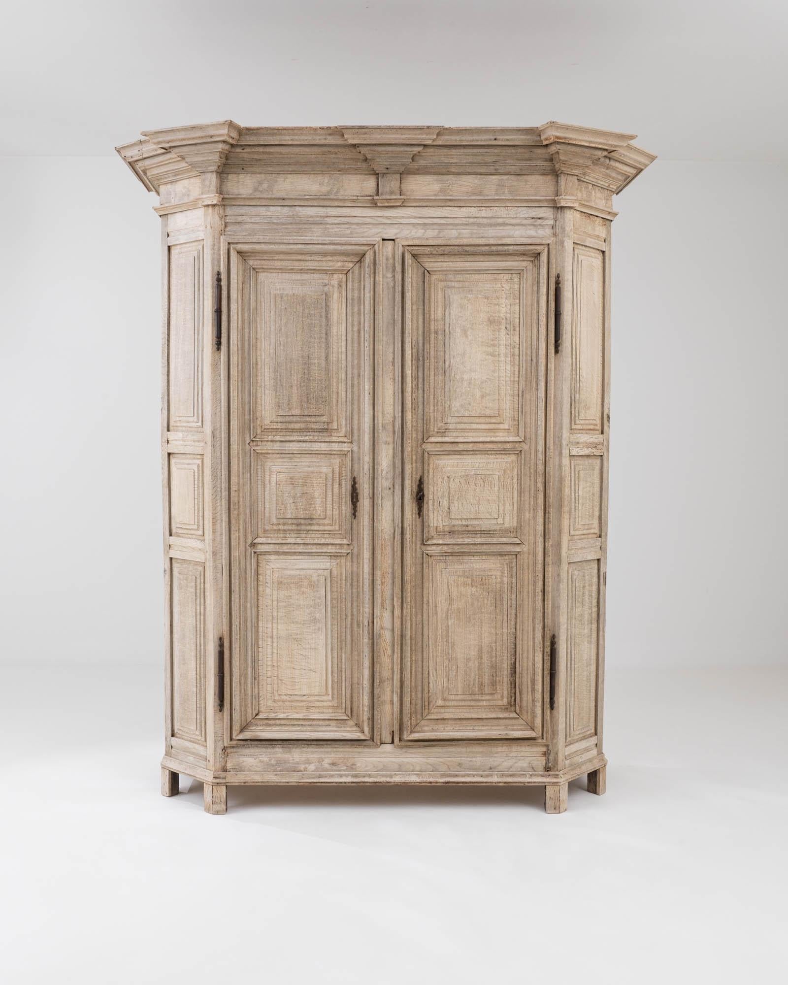 Elegant, eye-catching and beautifully crafted, this antique oak armoire casts an enchanting spell. Made in Belgium in the early 19th Century, the design combines a dramatic silhouette with delicate carved detail. An impressive crown molding