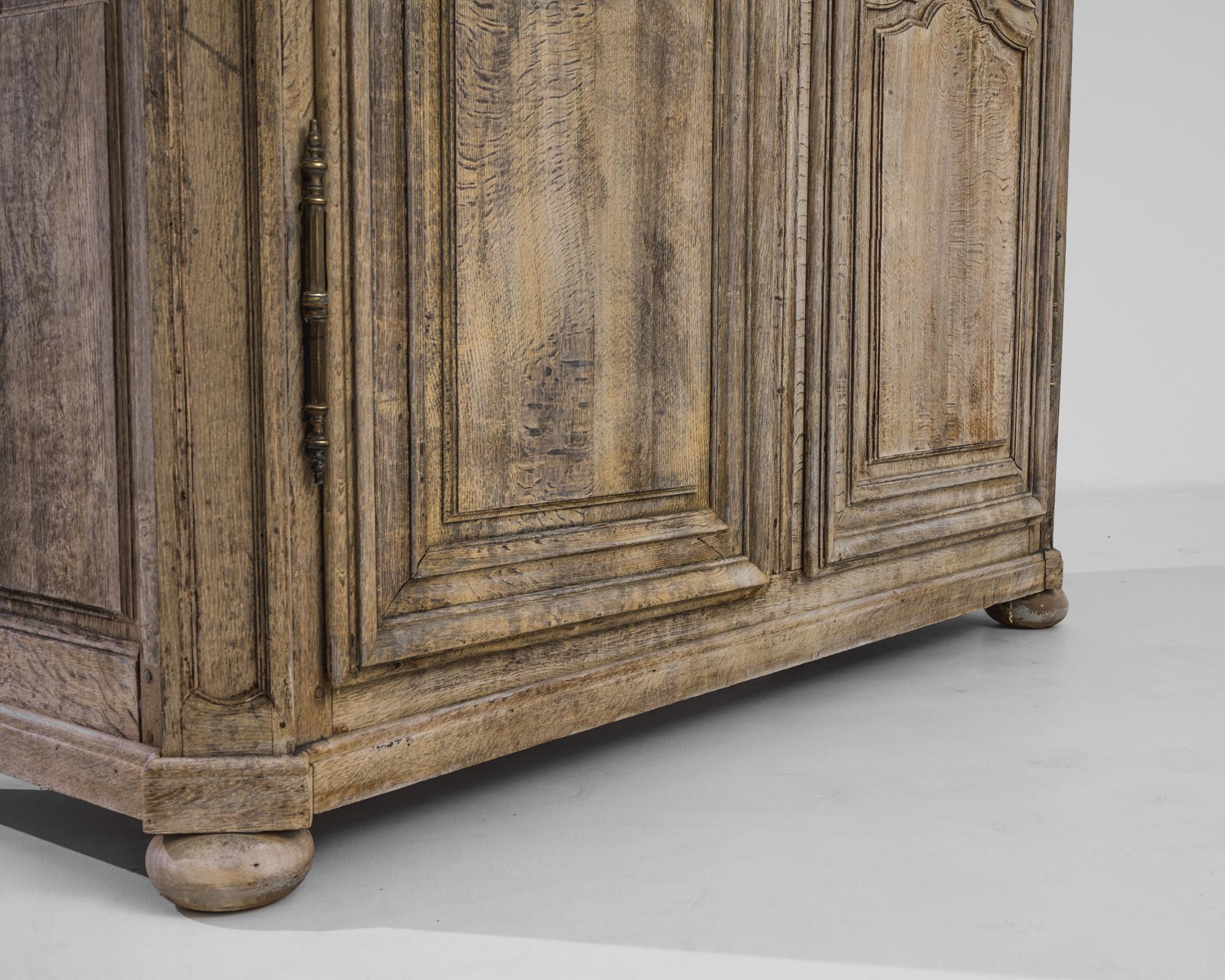 This elegant 19th century Belgian oak armoire was crafted in 1800 and is a timeless piece of that period. This remarkable piece encapsulates the unmatched artistry of Belgian craftsmen, emanating the charm of a bygone era. Intricate detailing adorns