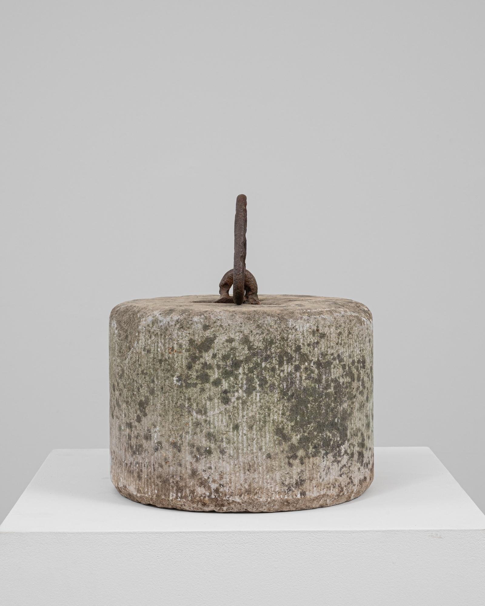 This 19th Century Belgian concrete door stop is a robust example of utilitarian form turned sculptural artifact. Cylindrical in shape with a subtly ribbed texture around its sides, the surface bears the weathered patina of age, blending earthy