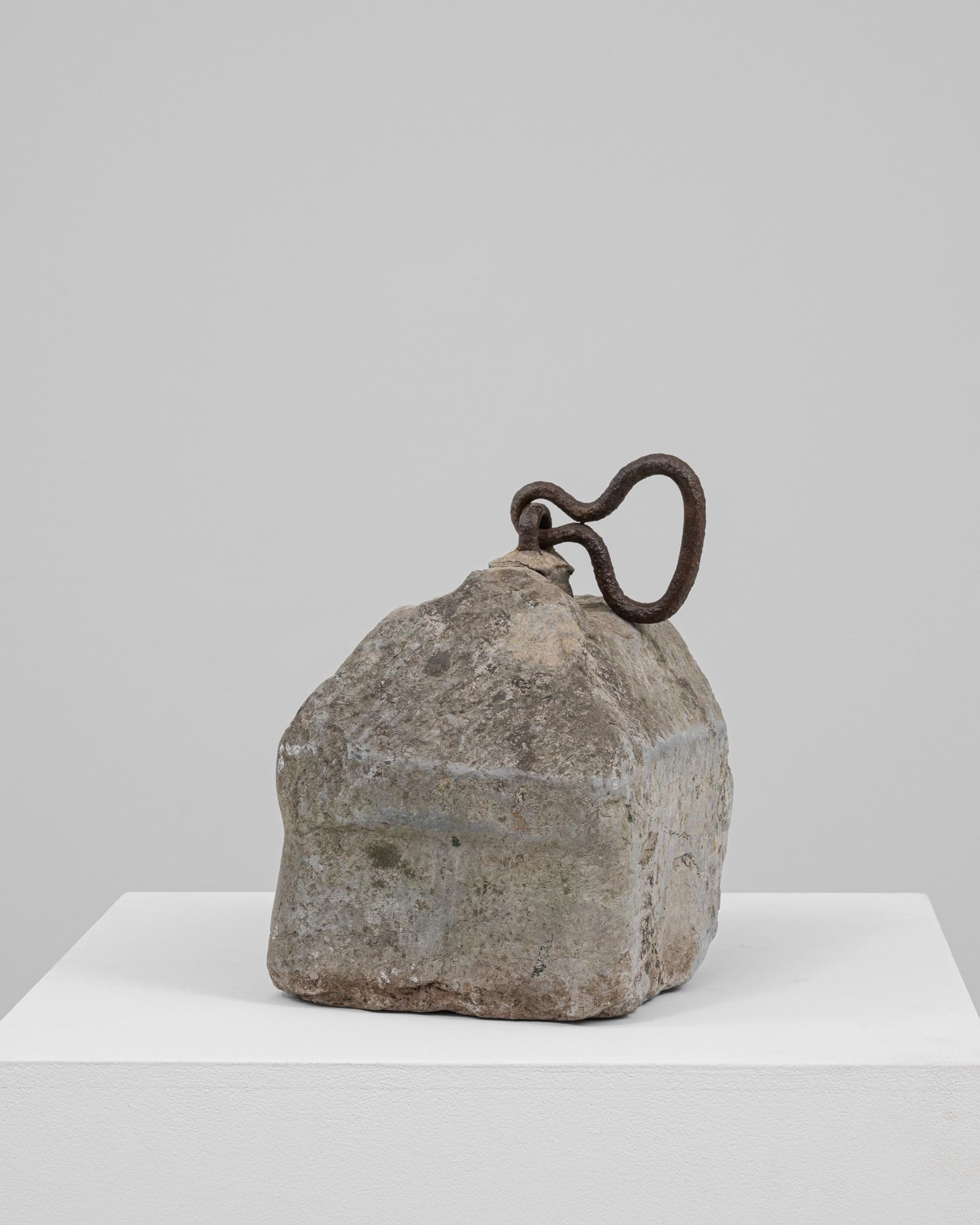 This 19th Century Belgian concrete door stop is a distinctive piece with a striking, irregular form shaped by time and use. Its angular, almost pyramidal body showcases a richly aged surface marked by natural weathering, subtle discoloration, and