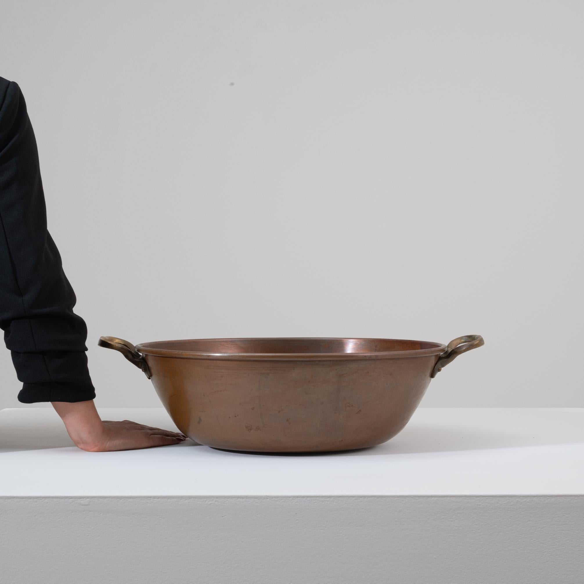 Questa pentola in rame belga del XIX secolo è un esempio di lavorazione utilitaria del metallo europeo, apprezzata oggi sia per la sua presenza scultorea che per il suo carattere antico. Realizzato in rame di grosso calibro con una patina calda e