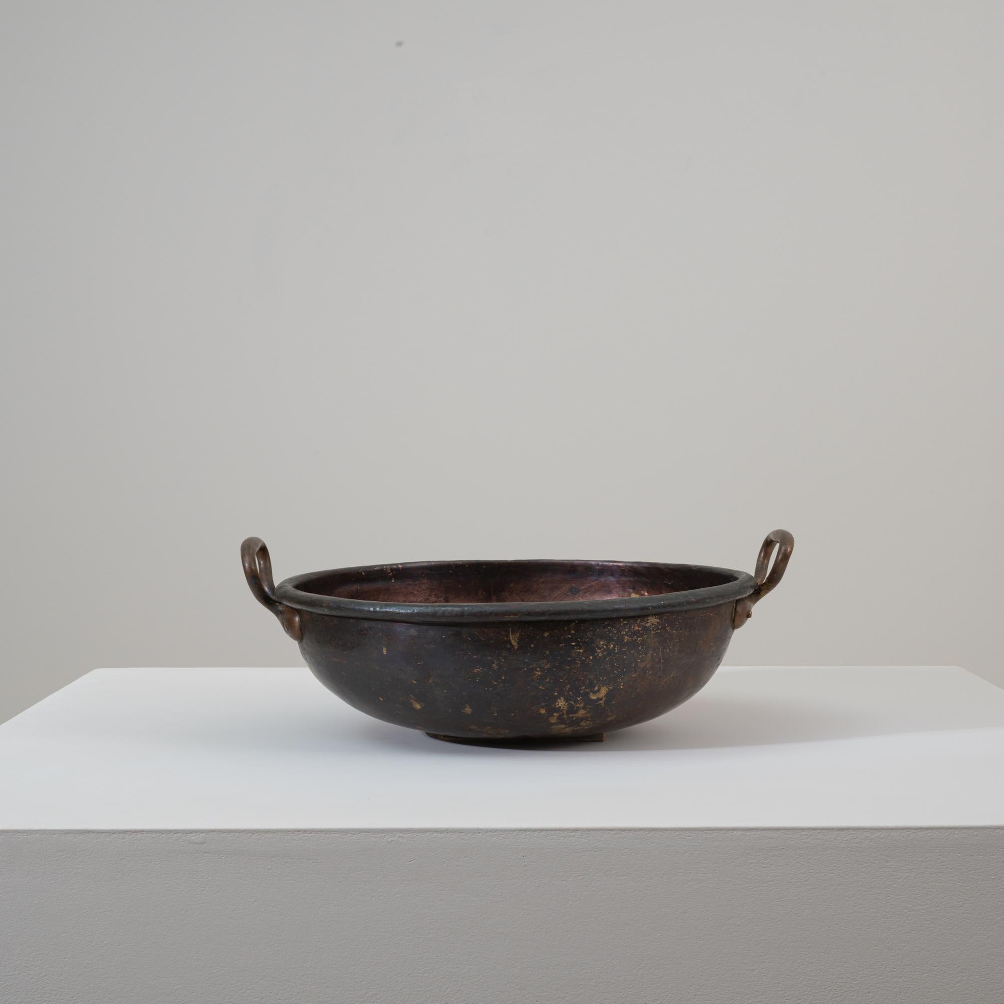 Questa pentola in rame belga del XIX secolo è un recipiente utilitario splendidamente invecchiato che mostra la ricca patina e l'usura tipica delle pentole europee forgiate a mano dell'epoca. La forma arrotondata del bacino, l'ampio bordo e le