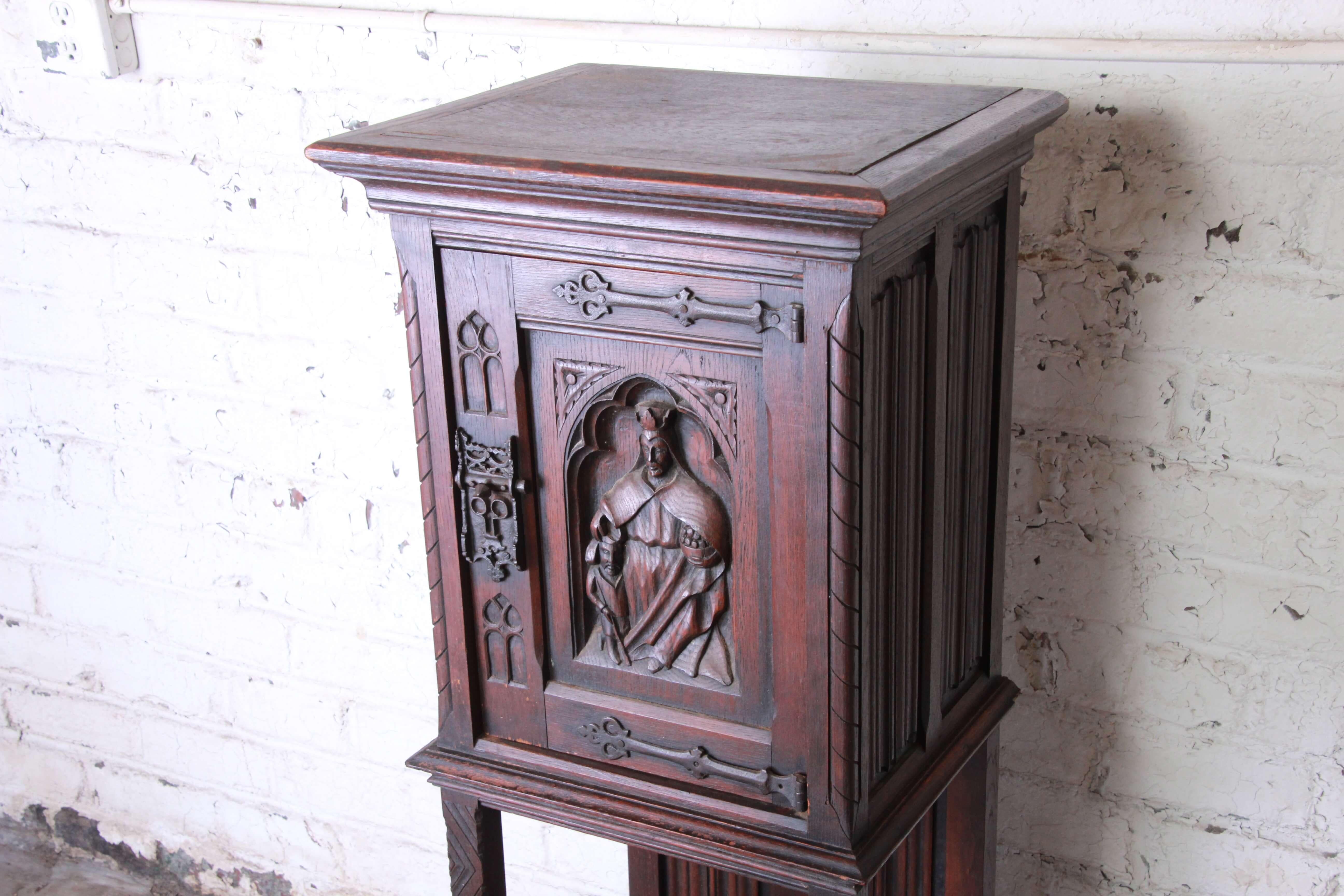 Offering a very nice 19th century Belgian dark walnut gothic bar cabinet. The cabinet has a carved religious figure giving it a unique style as a liquor cabinet or storage cabinet. The piece is for the mid-19th century and marked made in Belgium on