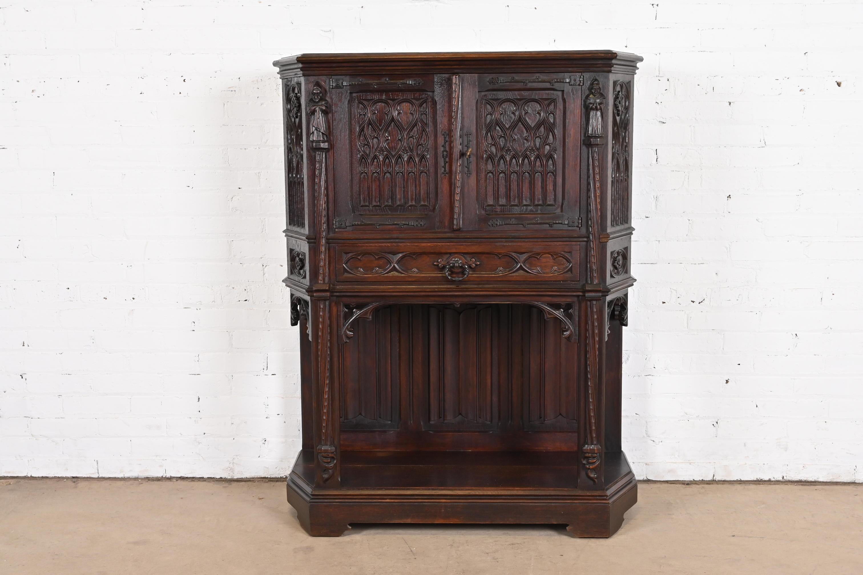 A gorgeous antique Gothic or Renaissance Revival bar cabinet

In the manner of R.J. Horner

Belgium, Circa Late 19th Century

Carved dark oak, with original iron hardware.

Measures: 39.25