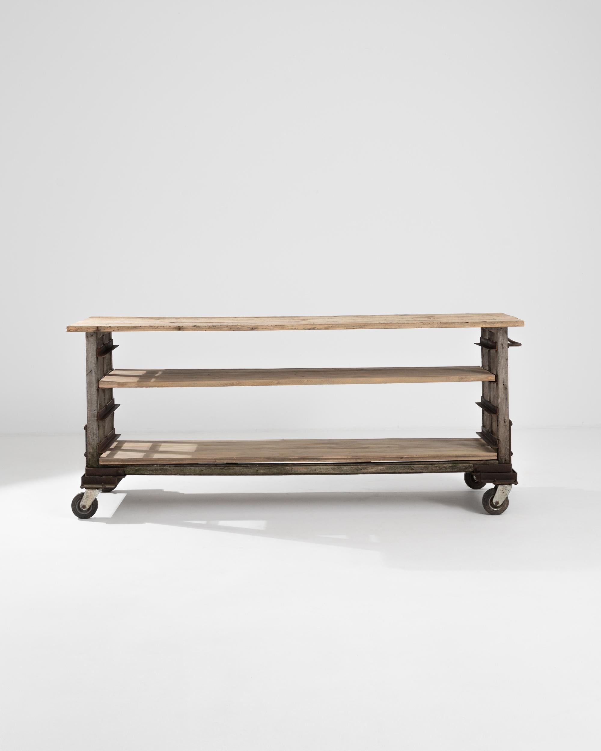 Weathered and robust, this antique Industrial cart makes a striking accent. Made in Belgium in the 1800s, this piece would have originally served a dedicated purpose in a workshop or factory. A wooden frame, reinforced with iron straps, sits upon a