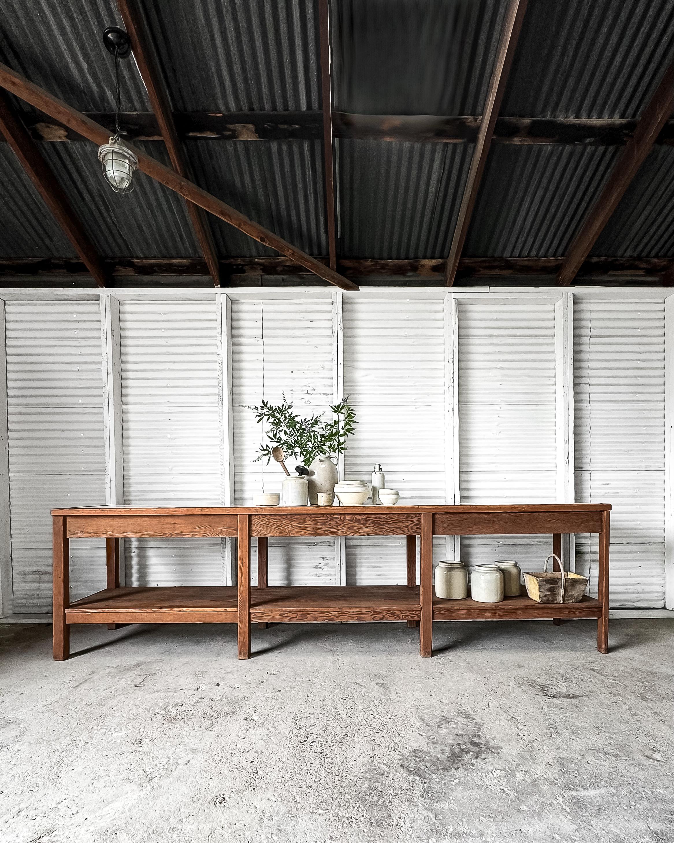 This 19th-century laboratory table, sourced from Liege University in Belgium, has been reimagined as a handsome kitchen island that effortlessly combines history with modern functionality. Crafted from natural wood, the table features a lower shelf