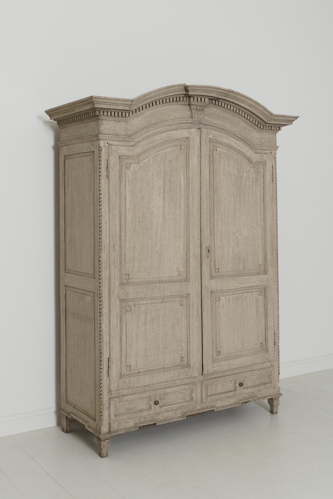 A 19th century Belgian linen press from the Flemish area of northern Belgium. This versatile piece is wearing original taupe-gray paint that has been refreshed in some areas. There are two doors and two drawers below. On the interior there is one