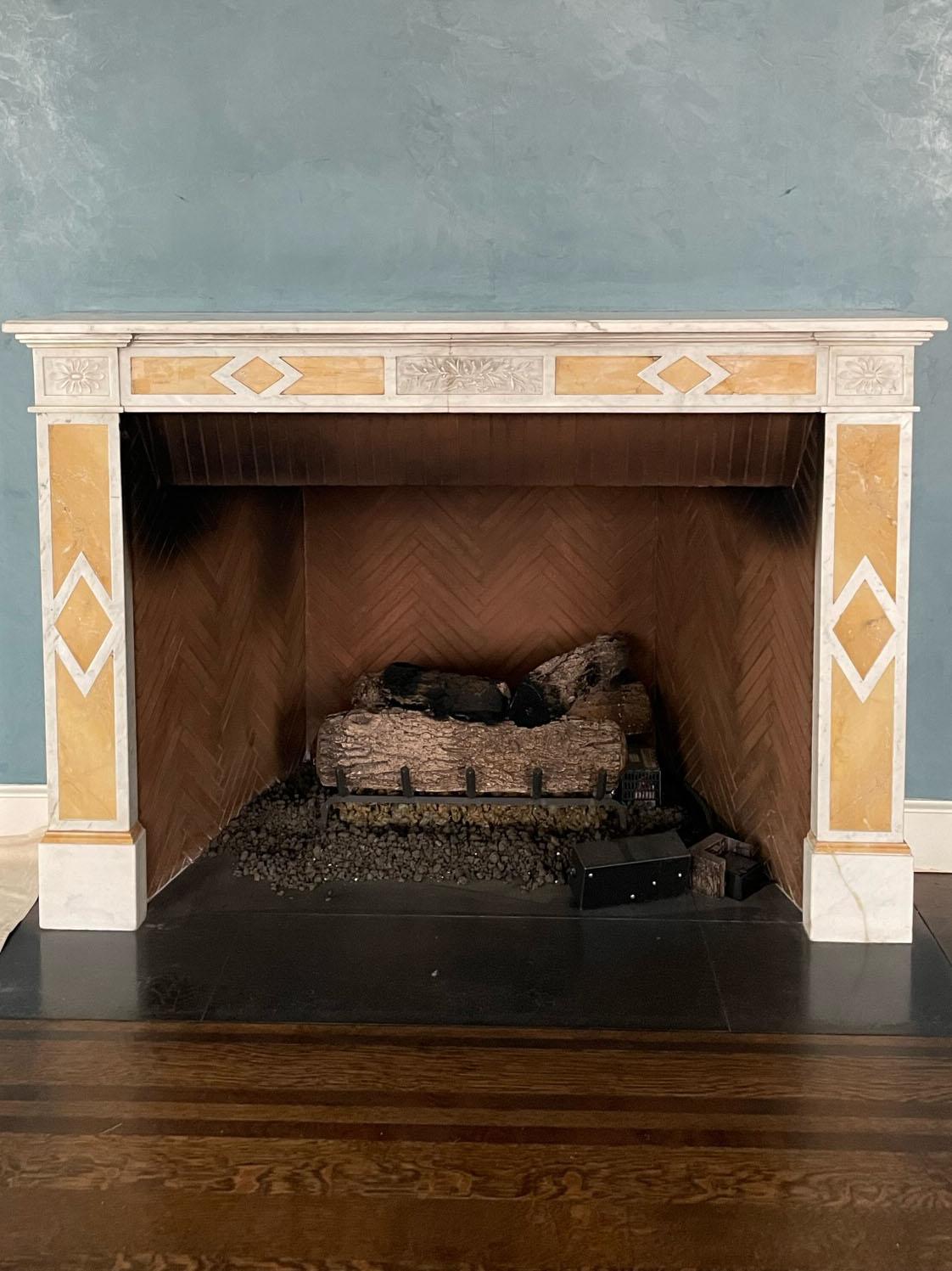 A late 19th century Belgian mantelpiece in Carrara marble with Giallo Siena inlay.
 