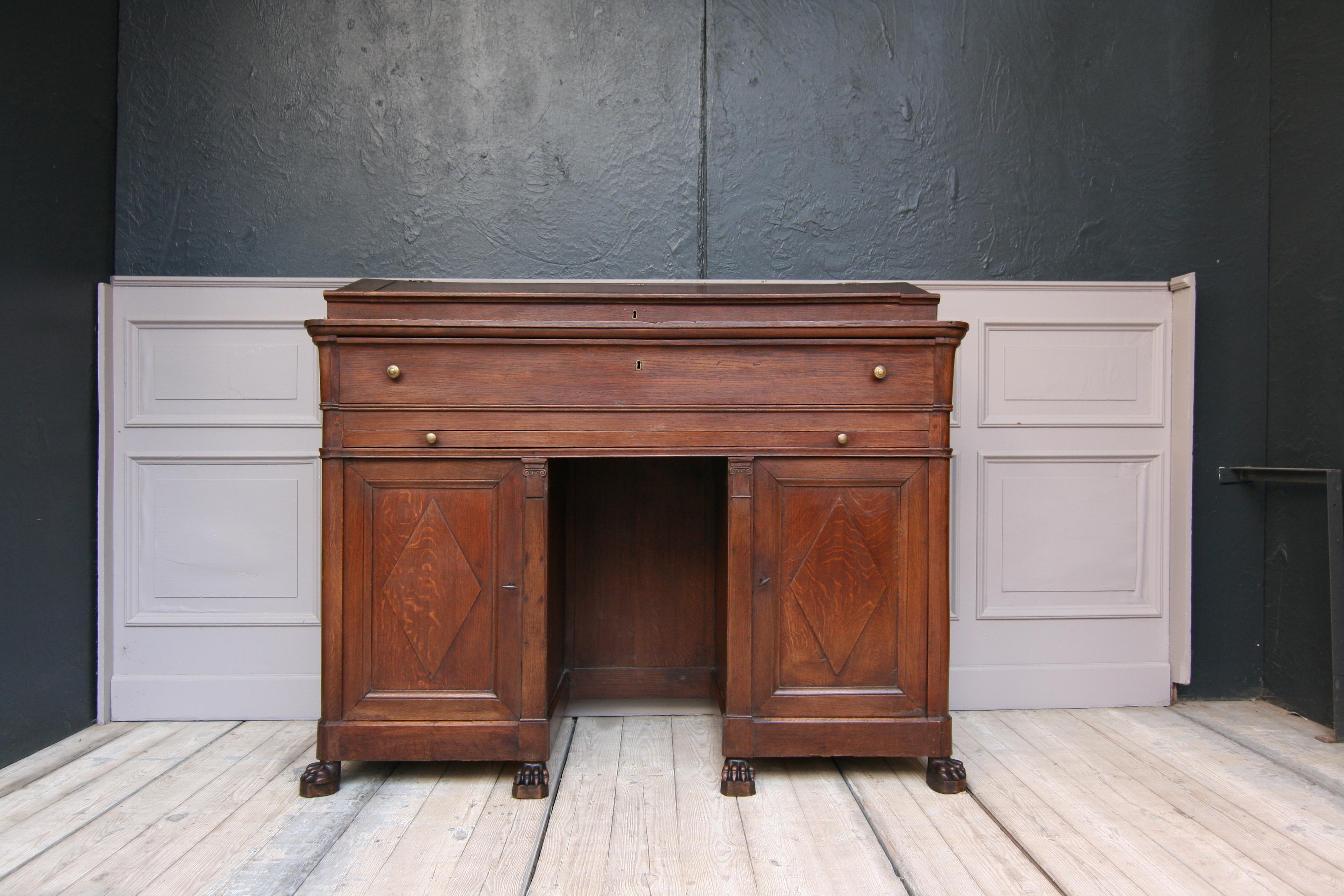 Original notary desk or writing furniture from the 19th century in Belgium. Made of solid oak.
Standing on lion feet, 2 firmly connected base cabinets, each with a door behind which there is a drawer and a shelf. The lion's paw feet indicate the