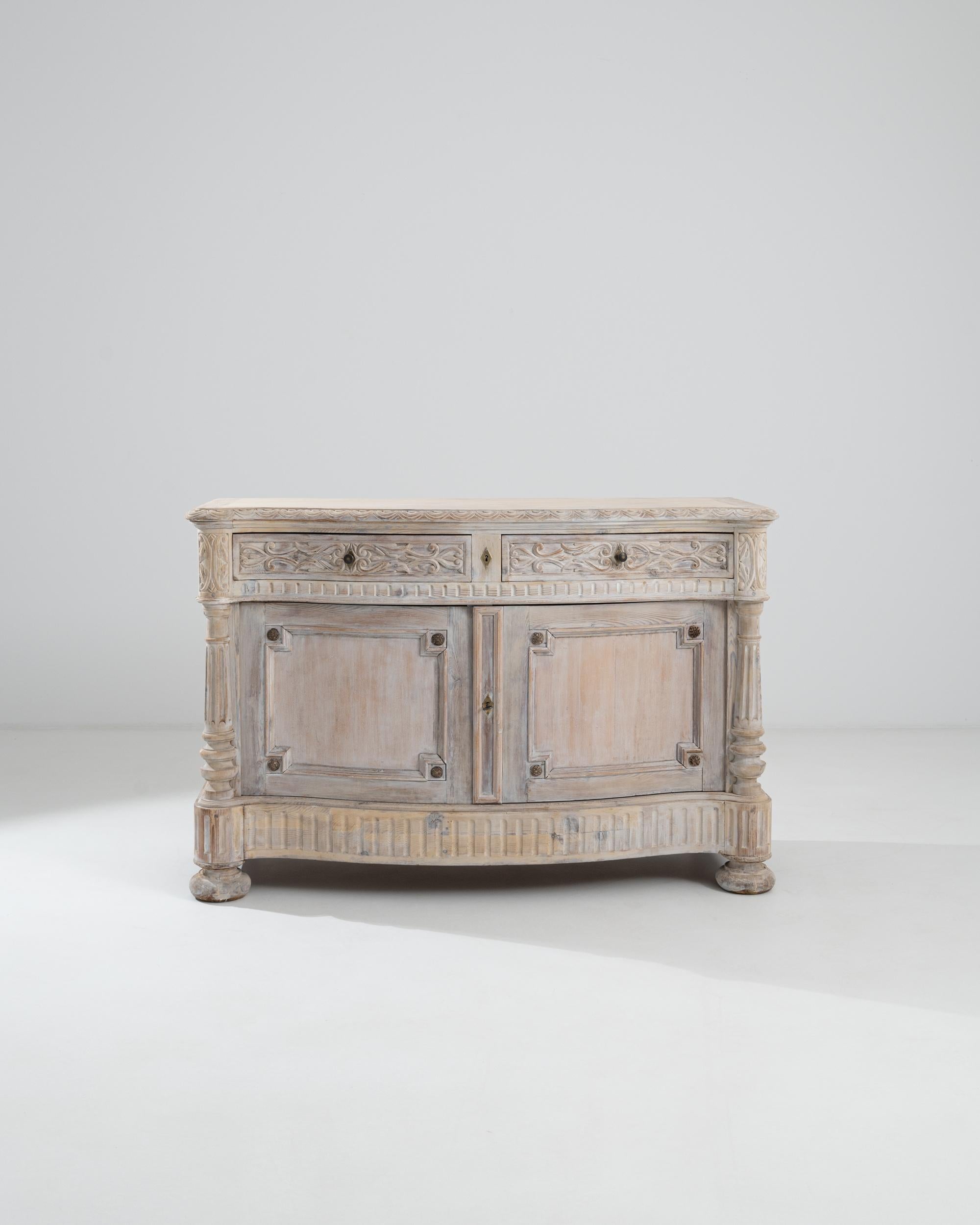 This magnificent carved wooden buffet offers a unique antique accent. Made in Belgium in the 1800s, a gentle patina lends a dreamy inflection to the grand and eloquent design. Geometric paneling and fluted moldings speak to Neoclassical influences,