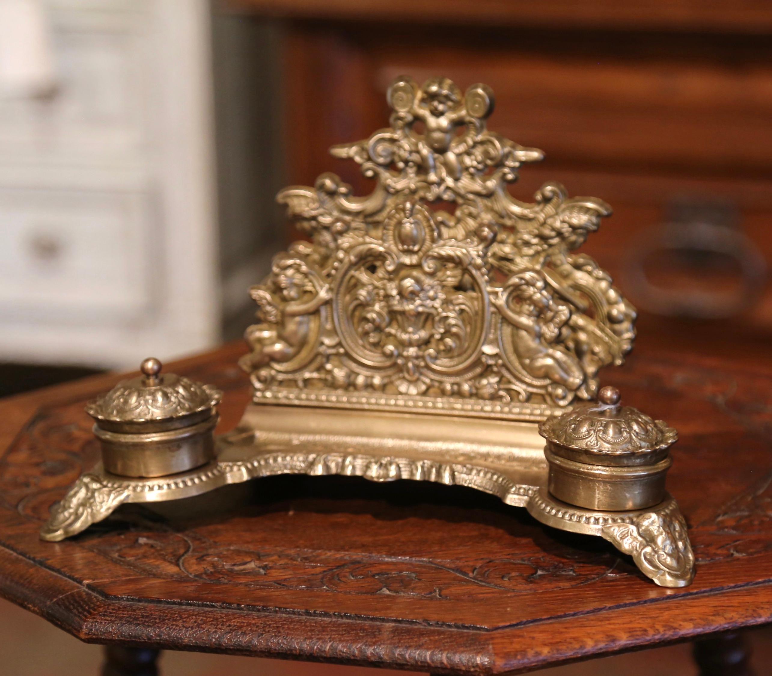 Decorate a man's desk or study with this elegant antique inkwell; crafted in Belgium, circa 1880, the desk accessory stands on scroll feet over a scalloped apron, and features intricate repousse decor including a deep curve at the front for pen