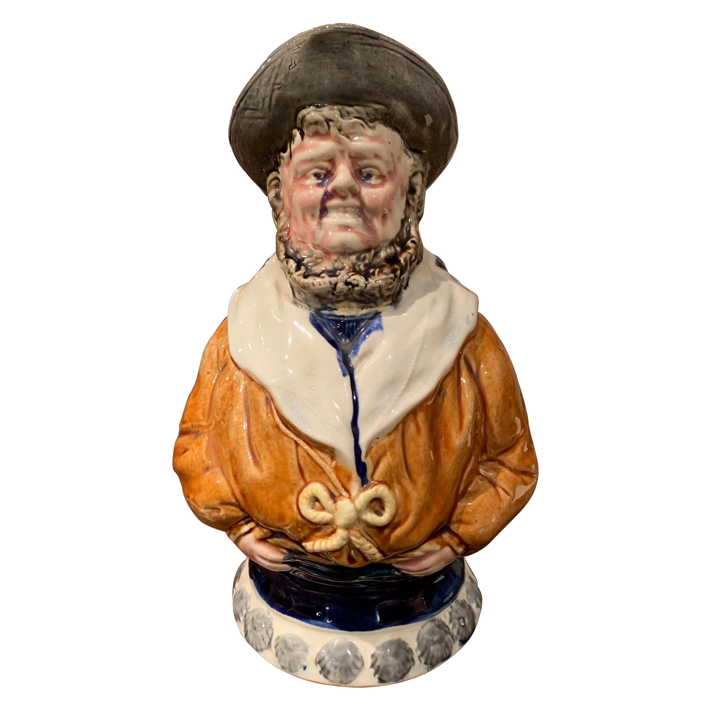 Decorate a wet bar with this charming, sculptural Majolica pitcher, crafted in Nimy Les Mons, Belgium circa 1890, the antique, barbotine jug similar to the one of Onnaing, features a smiling sailor with his hands holding his pants in a defiant pose.