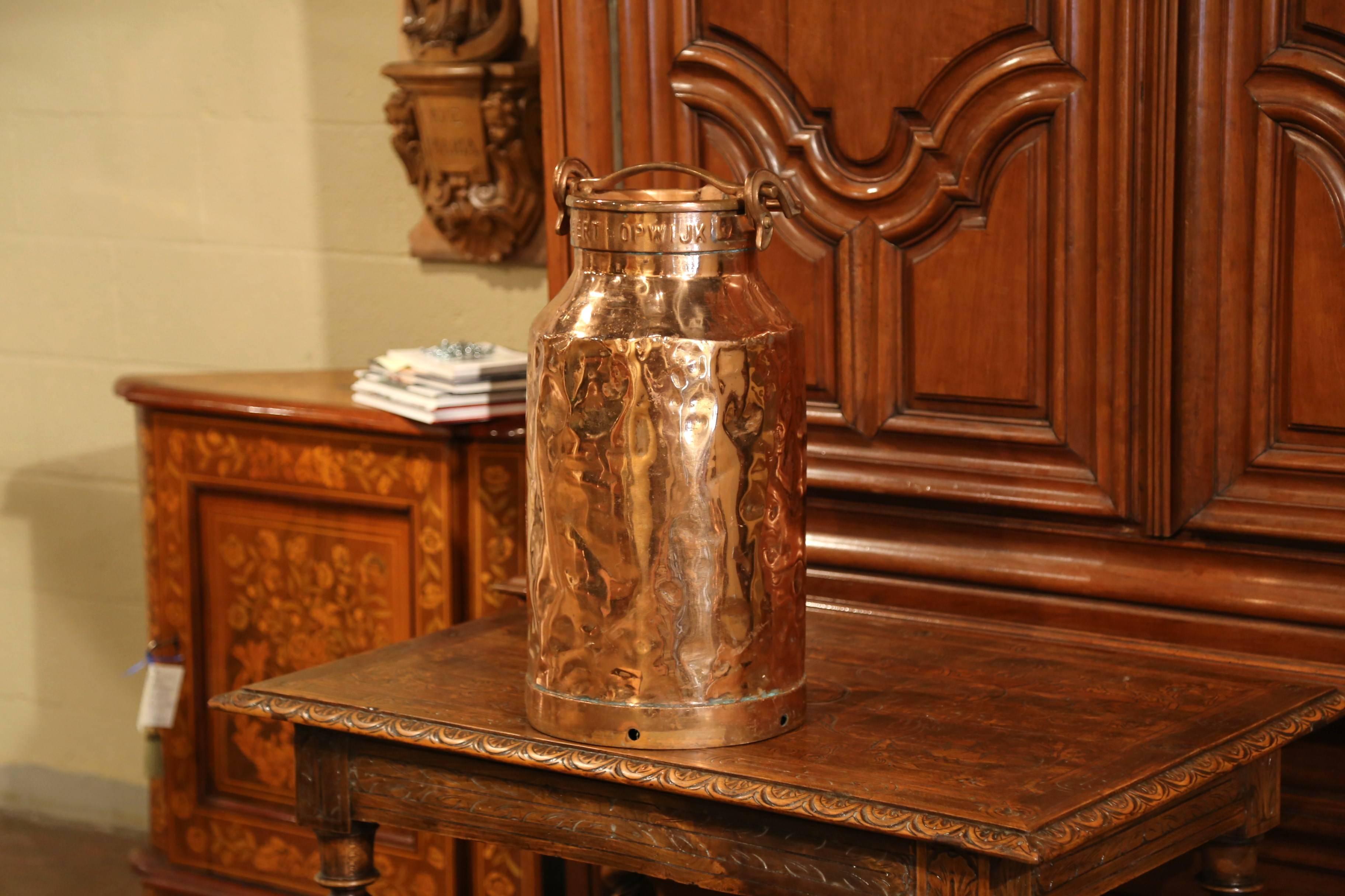 Use this beautiful antique milk can as an umbrella stand by your front door! Crafted in Belgium circa 1880, the tall copper container with the original attached lid and handle is in excellent condition with patinated finish. The jar features the