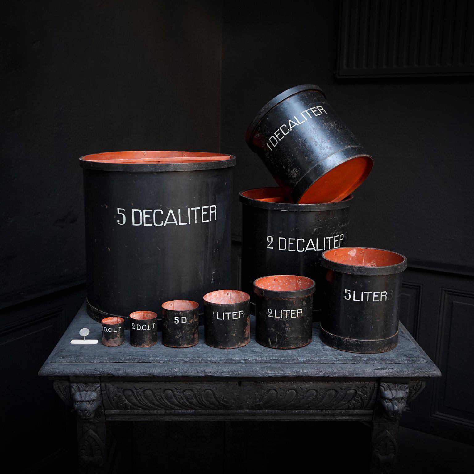 Set di misure in ferro antico di capacità ton per uso didattico.

Splendidamente invecchiato, con una patina leggermente arrugginita ma ancora molto robusta.
Le lettere bianche sono dipinte a mano sul ferro verniciato di nero.
Venivano utilizzati