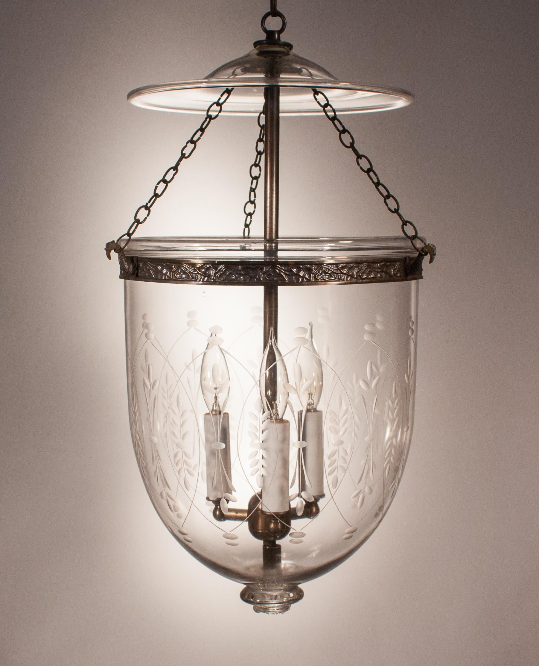 An antique bell jar lantern with superb quality hand blown glass. This authentic, circa 1890 hall lantern has appealing form that is accentuated by an etched wheat motif. The decorative brass band has been replaced to ensure the integrity of the