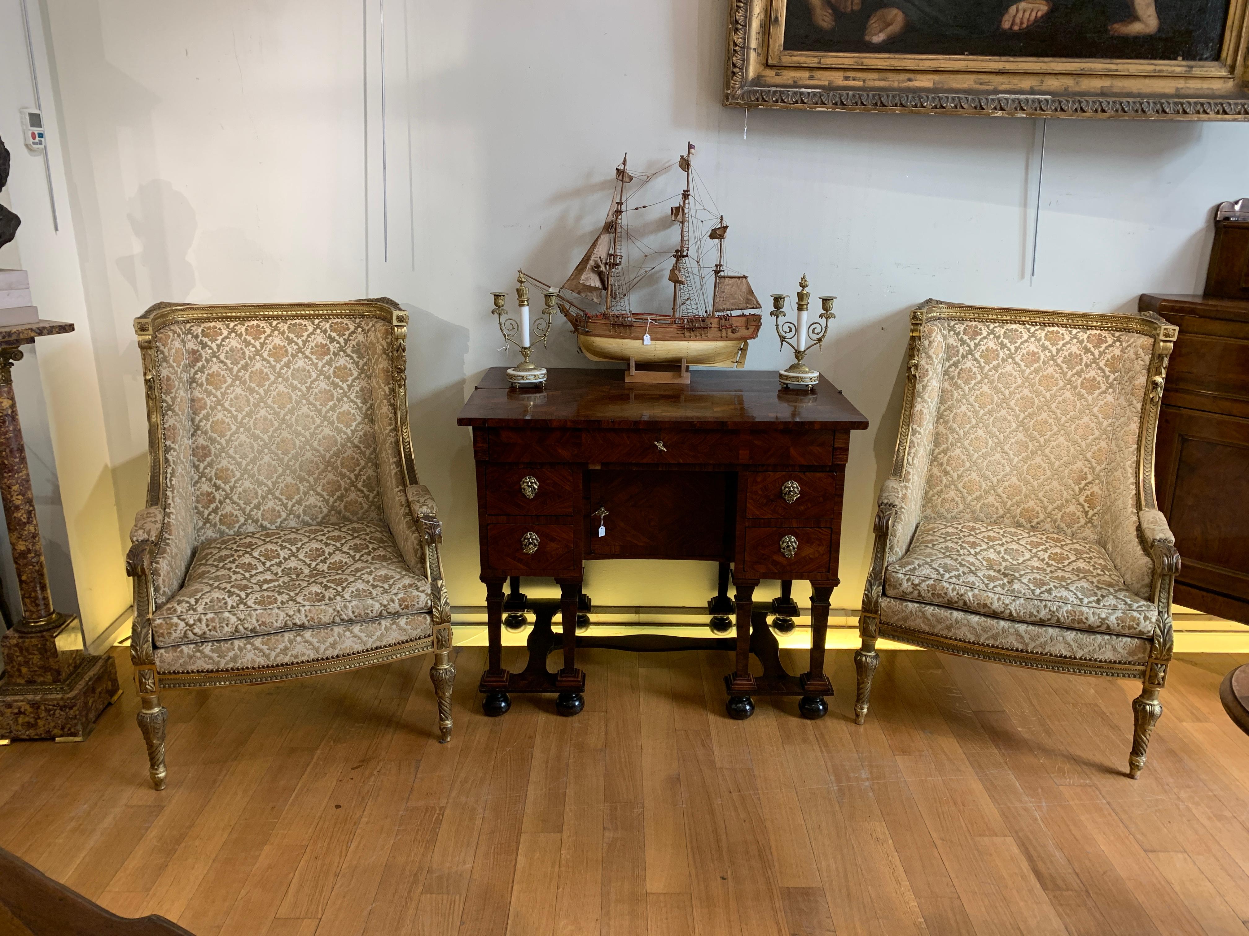 Refined pair of armchairs in the Bergère model, in gilded and carved pine wood. The upholstery is original, recalling phytomorphic motifs and weavings. The padding is also in excellent condition and ensures a comfortable seat for the armchair. The