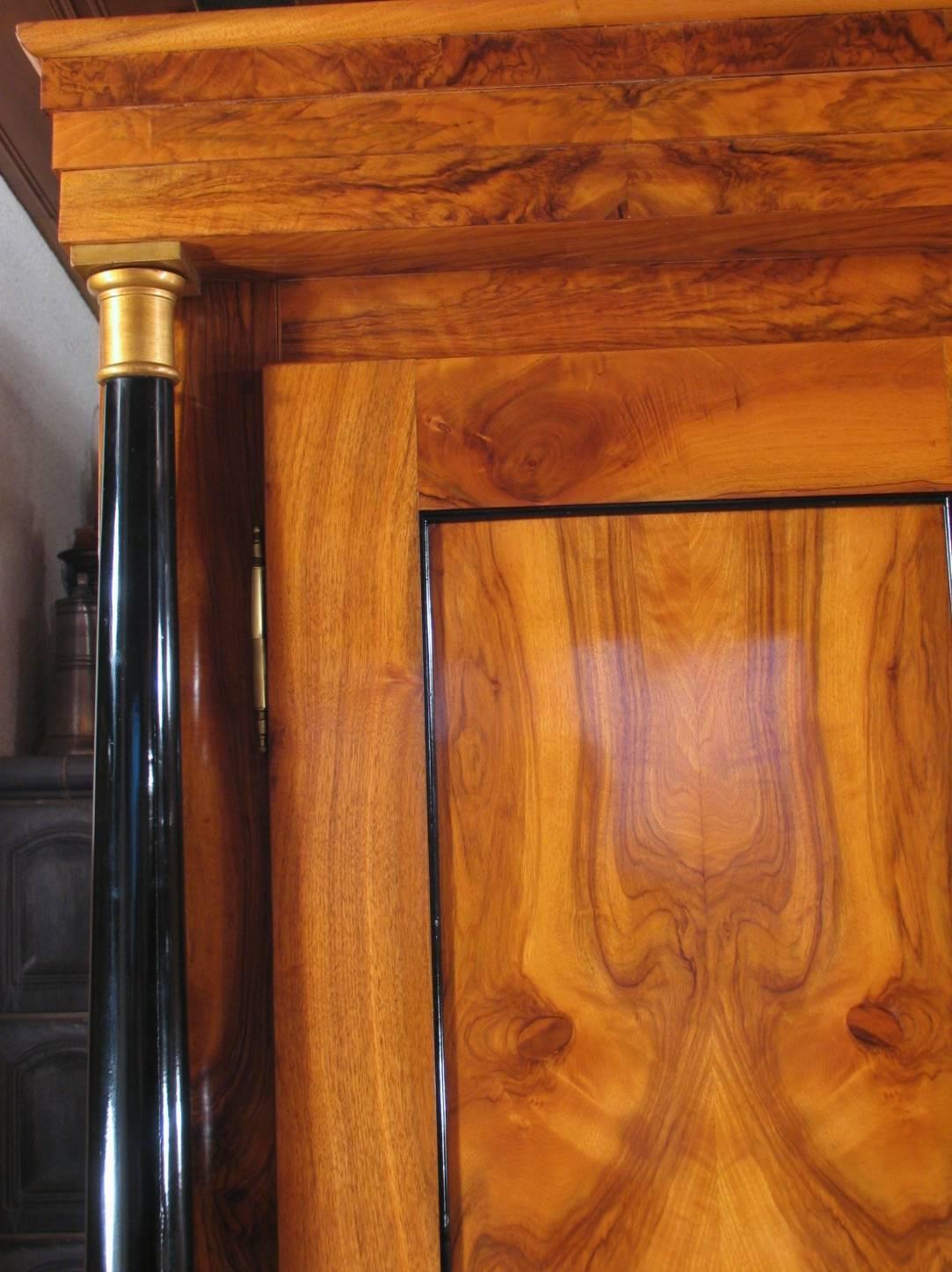 Klassisches Beispiel eines originalen Biedermeierschranks aus der Frühphase des Biedermeier um 1820.
Der Schrank zeichnet sich durch sein schönes Walnussfurnier an den Seiten und Türen aus. Ebonisierte Säulen mit vergoldeten Holzbasen und Kapitellen
