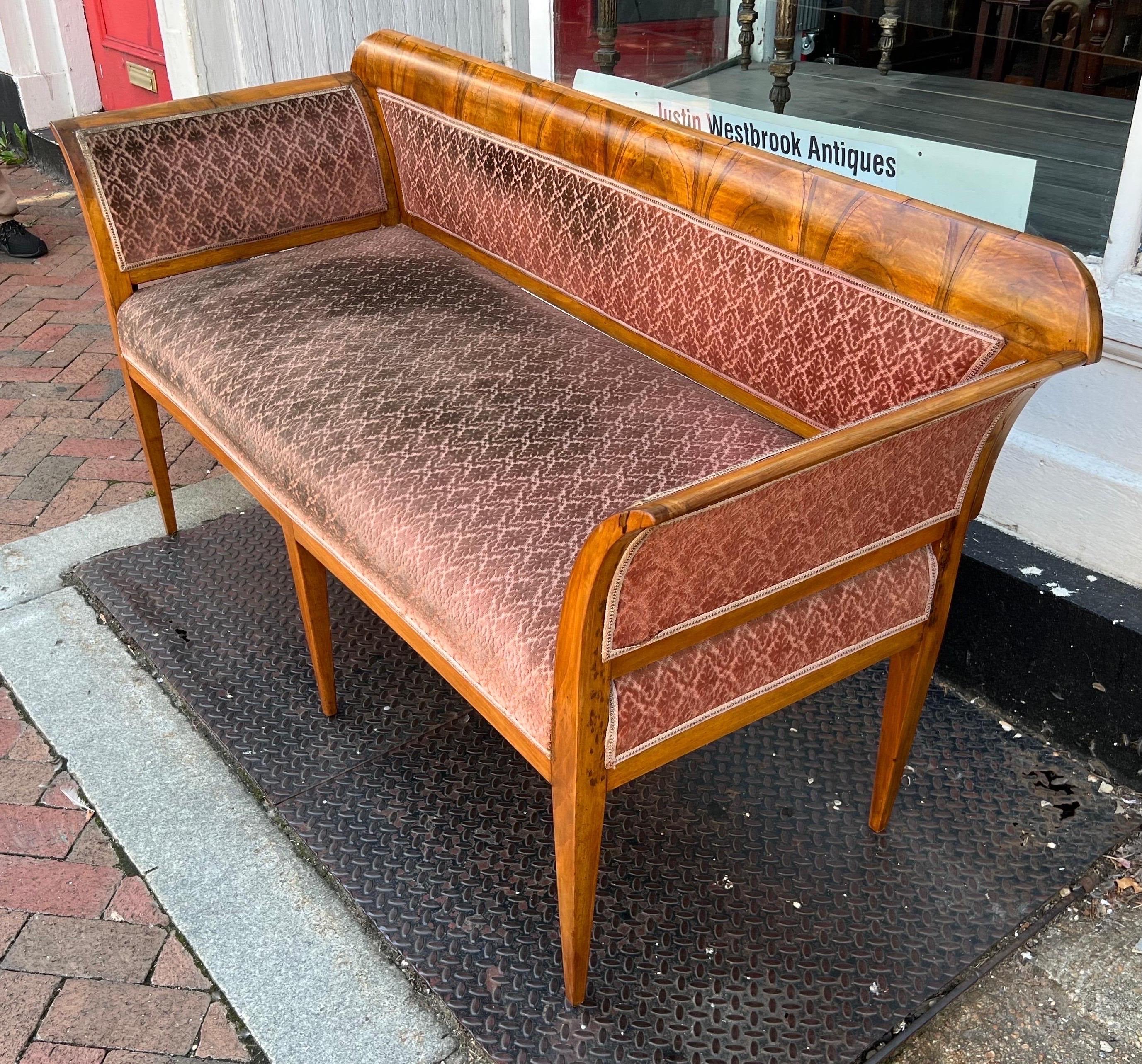 Lovely little 19th century Biedermeier bench or loveseat with neoclassical legs. Made of cherry and/or pear wood with crotch walnut veneers, this bench is simple yet elegant. Fabric needs a good cleaning but no tears or rips.