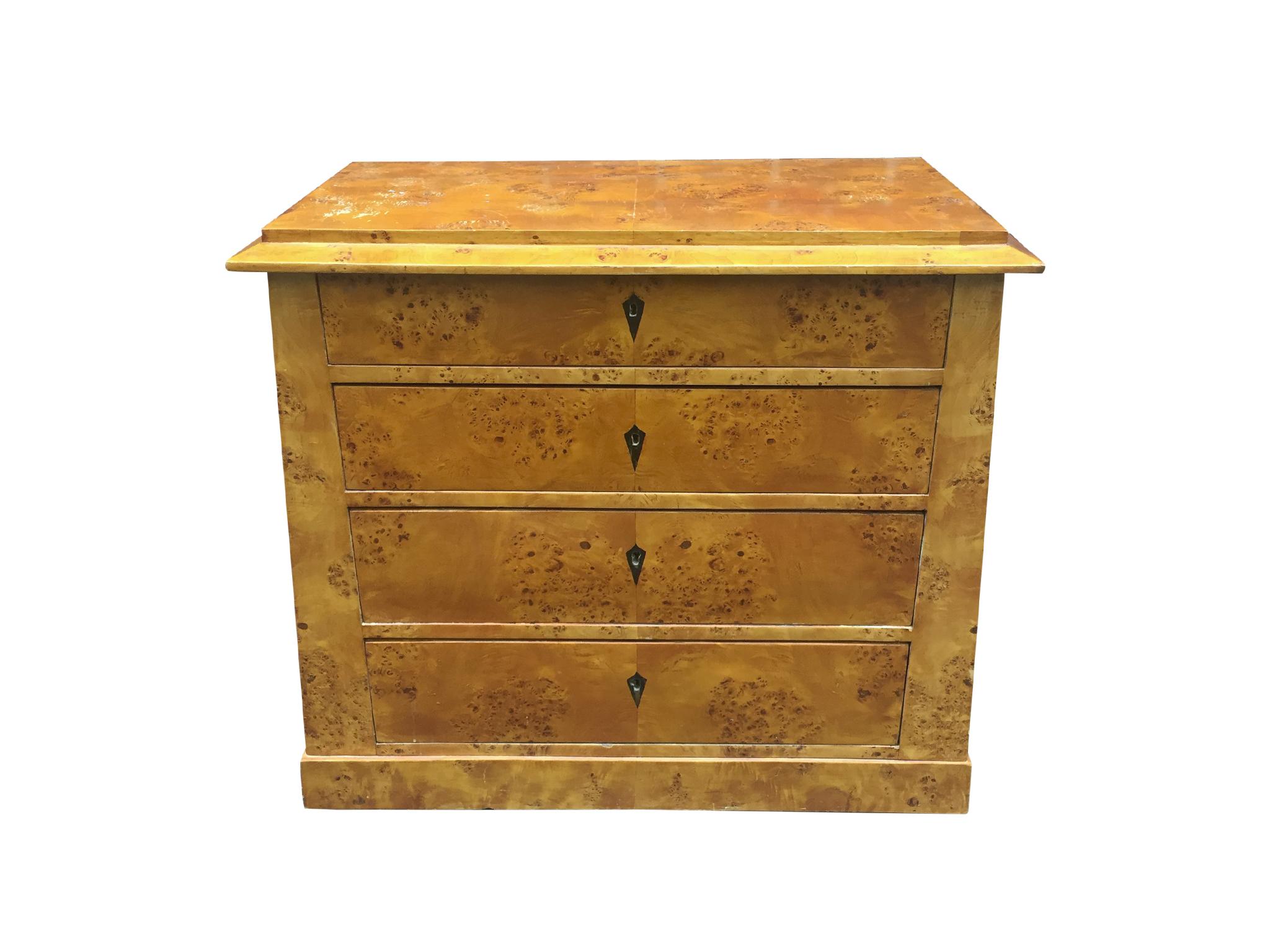 A beautiful Biedermeier chest of drawers or commode, 19th century. Expertly handcrafted with burl with a rich grain pattern. The wood is a warm, honey yellow-gold tone with a sheen. The arrangement of the chest is one of Classic symmetrical design.
