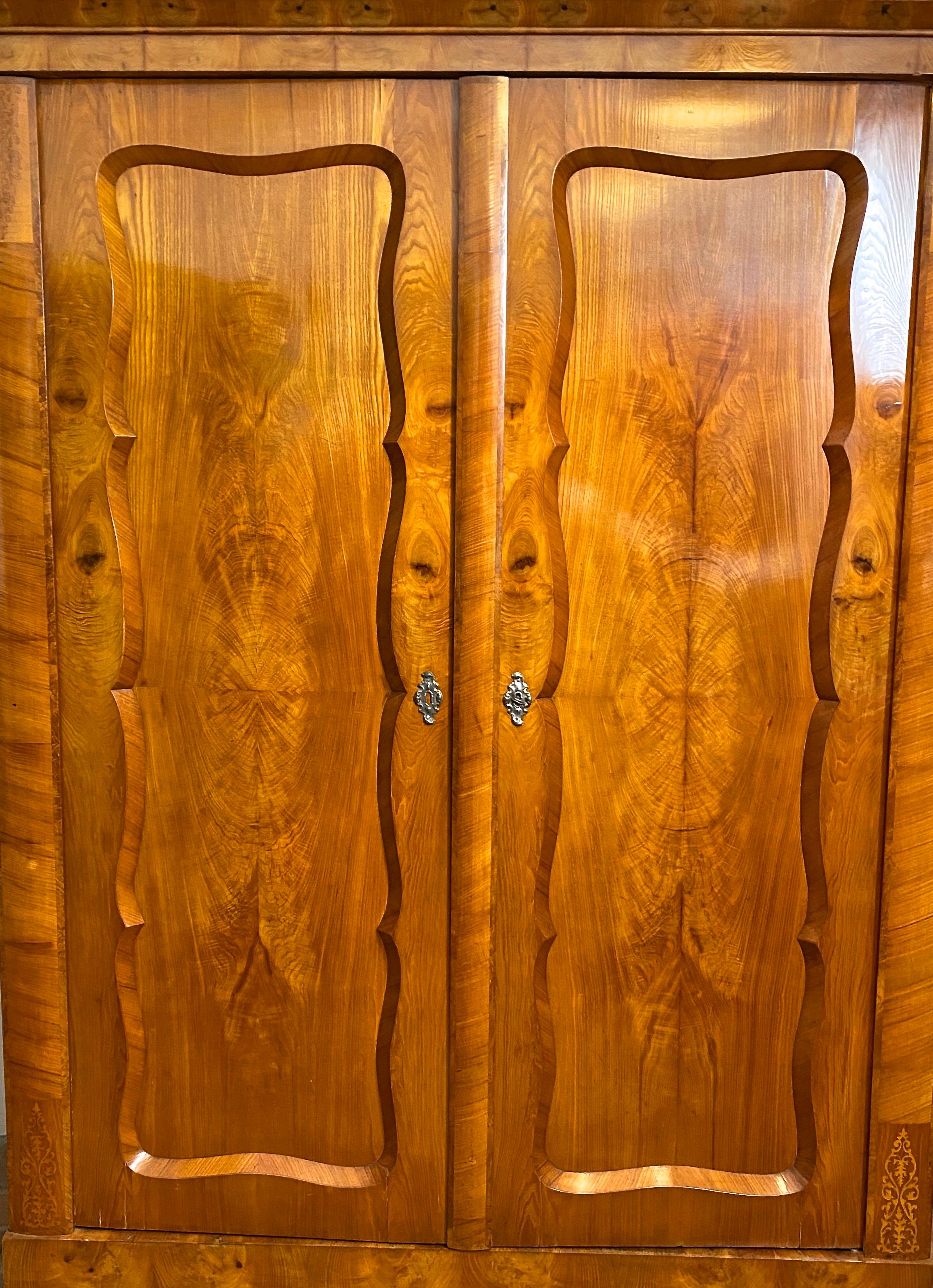 Remarquable et rare armoire autrichienne Biedermeier en bois de frêne, fabriquée à la main vers 1840. Le corps en épicéa massif est recouvert d'un placage de frêne très épais au grain magnifique, embelli par de fantastiques incrustations sur le