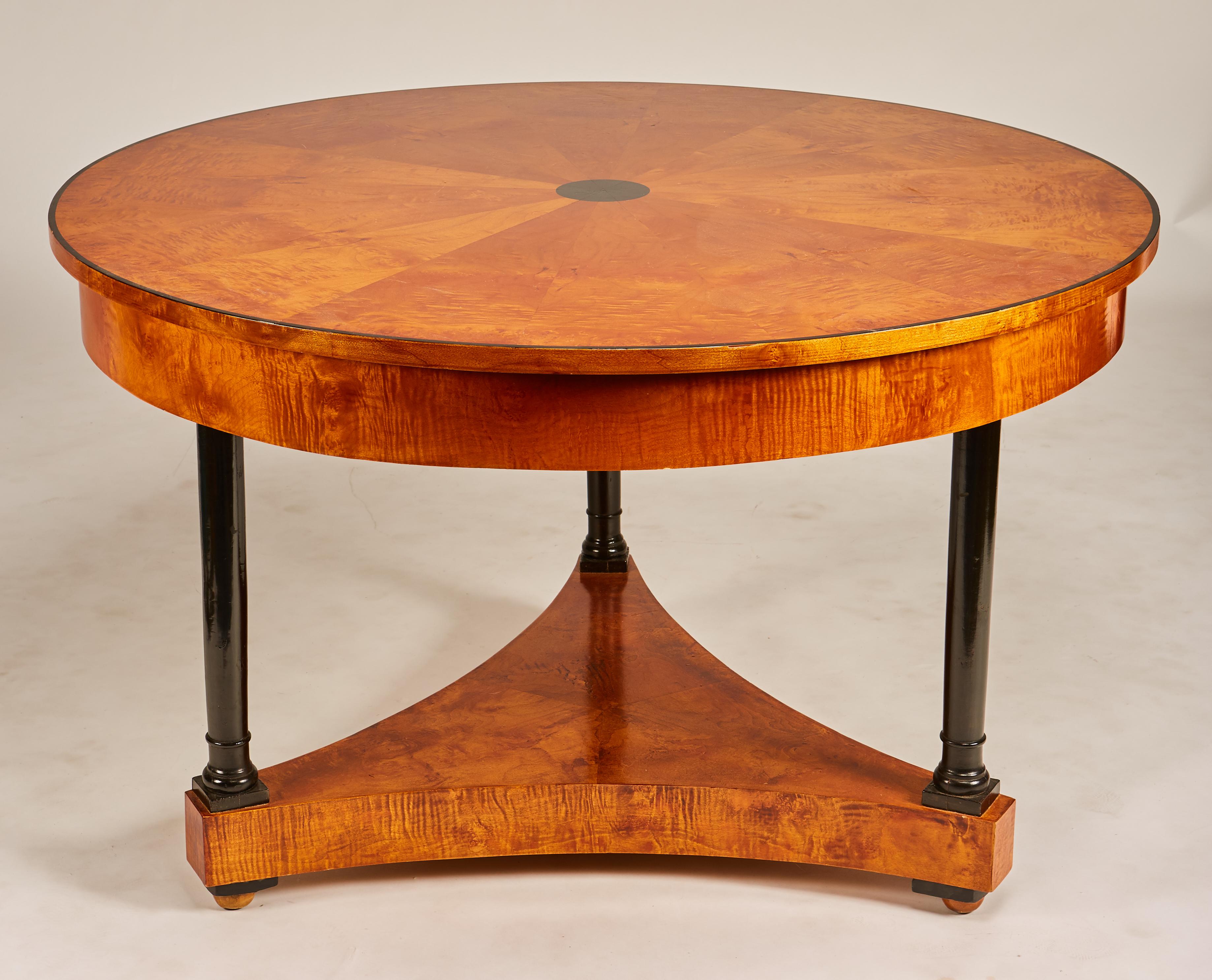 Beautiful early 19th century Biedermeier center table or round dining table with ebonized columns, pie shaped burl veneer inlay with ebonized center point decoration. Older restoration, shows well, minor scuffs to top.
     