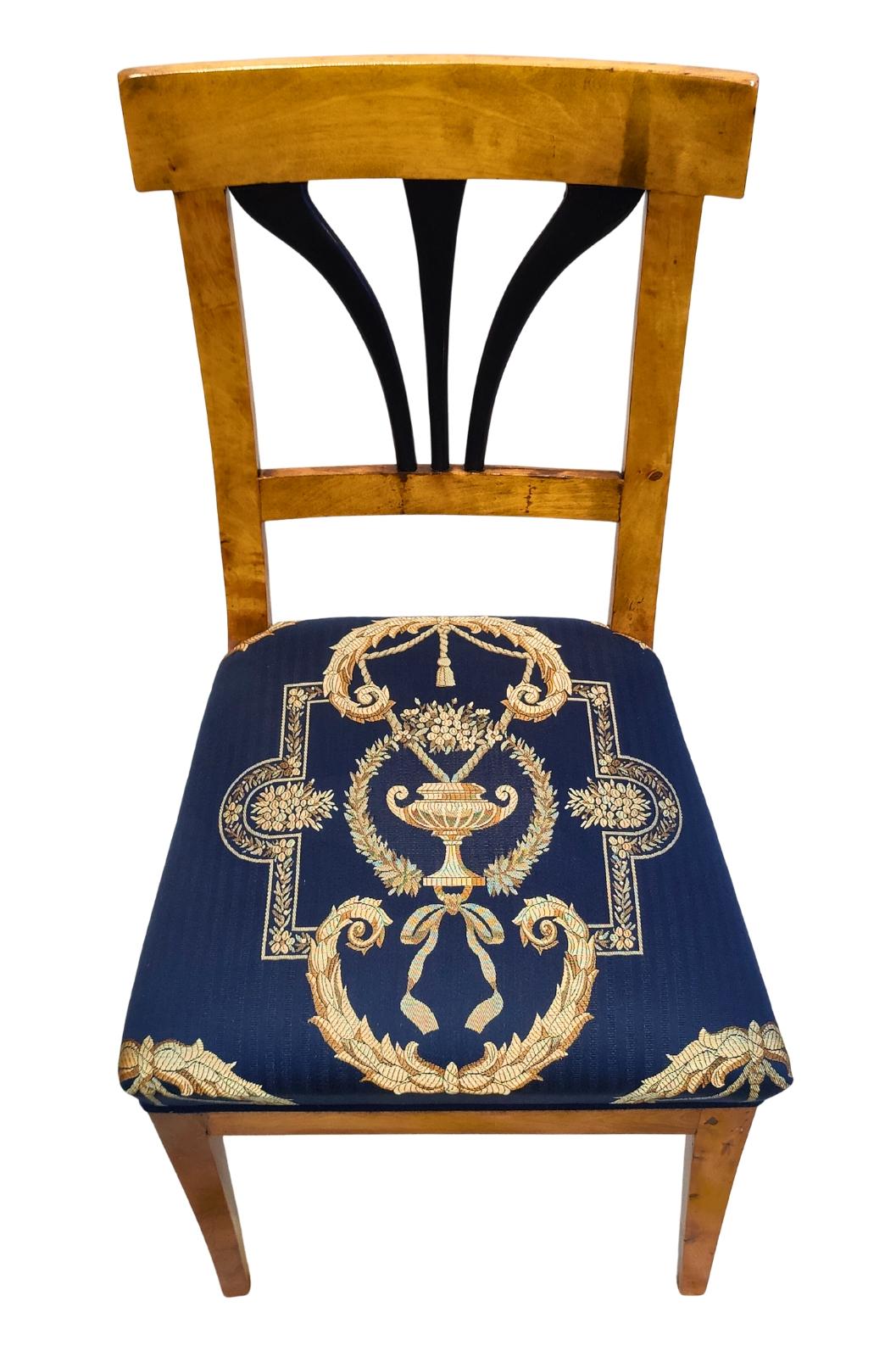 Elegante poltrona Biedermeier proveniente dalla Germania, circa 1825. La cornice è realizzata principalmente in betulla con dettagli in noce, che conferiscono al pezzo un'espressione calda e vibrante. La sedia è stata rivestita di recente con un