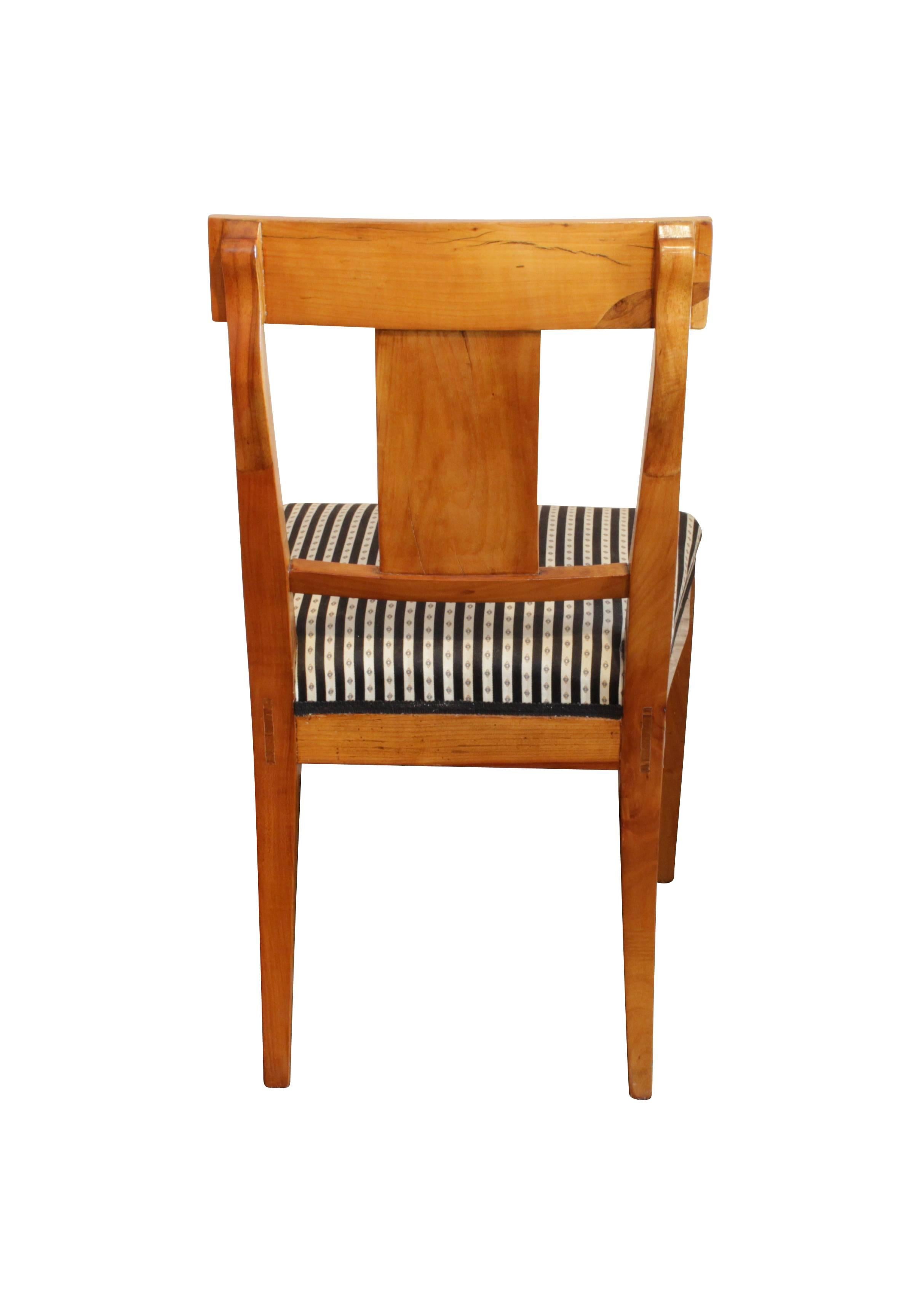 Classic upholstered Biedermeier chair. The chair dates from the Biedermeier period, circa 1815 and is newly upholstered in the traditional style with straps and springs. The chair is made of solid cherry.

Measures: Seat height 45 cm.