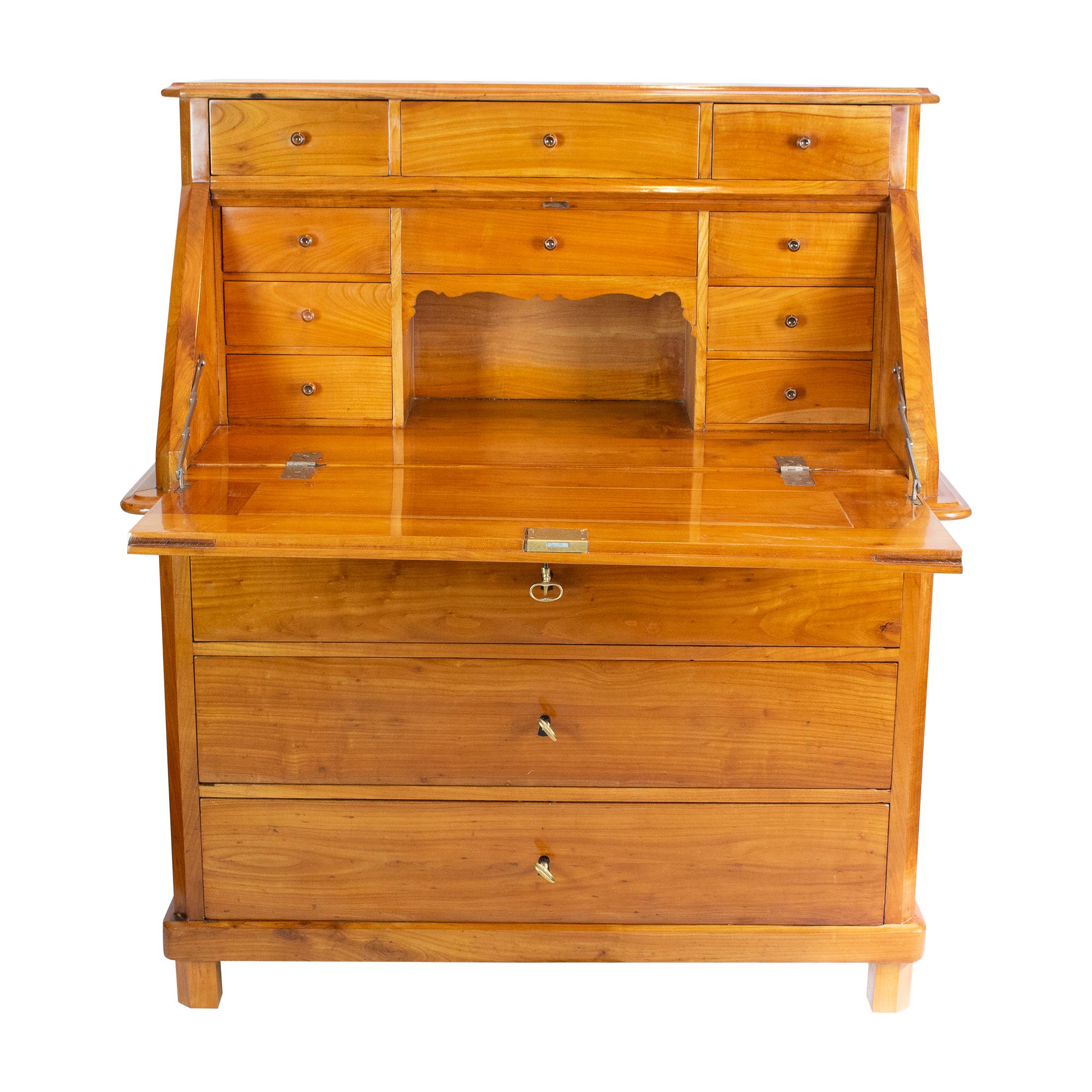 Introducing a stunning late Biedermeier Slant-Front Secretary, crafted from solid cherry wood in the 1840s. This exquisite piece of furniture features three drawers spanning the entire width of the base, providing ample storage space. The
