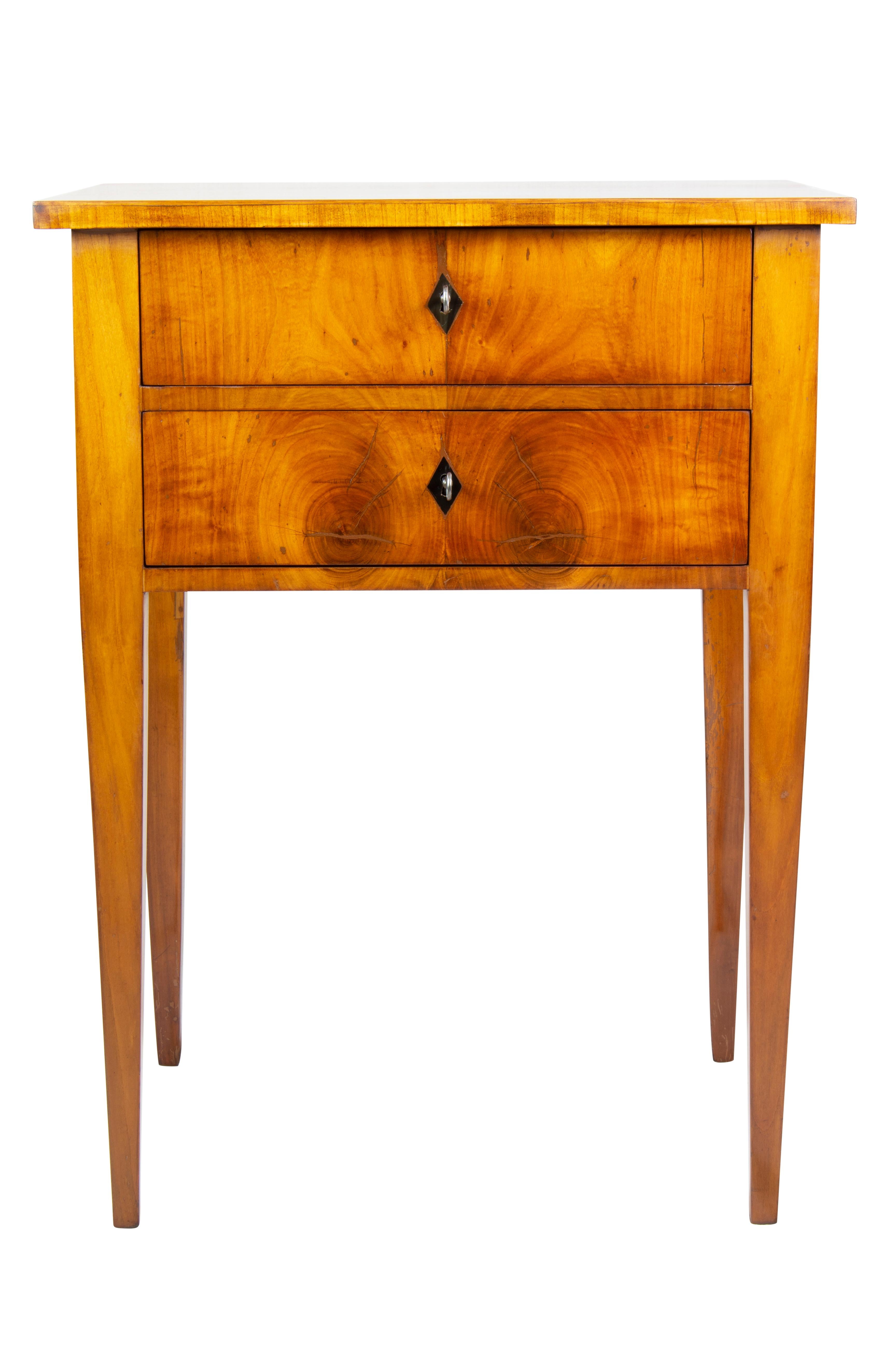 Classic Biedermeier side table with conical straight legs with 2 drawers, the top drawer with the original division. The side table is made of cherry wood veneered on spruce and solid cherry. The furniture is beautifully restored and hand polished