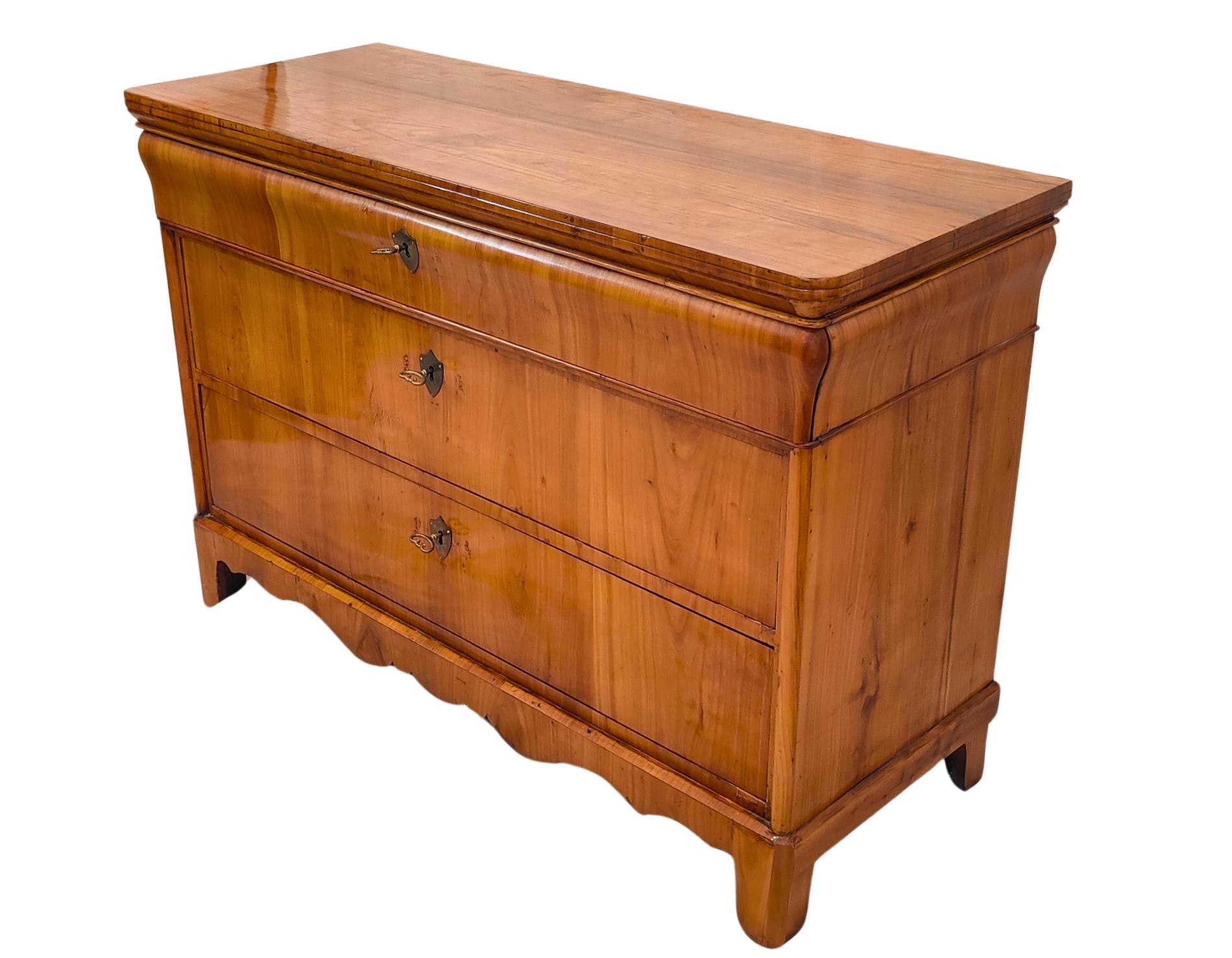 Cassettiera Biedermeier molto bella e pratica realizzata in legno massiccio di ciliegio. Il mobile ha tre cassetti Un brillante pezzo di Biedermeier di ottima qualità. Le dimensioni sono interessanti: il mobile è largo ma non profondo. Le chiavi